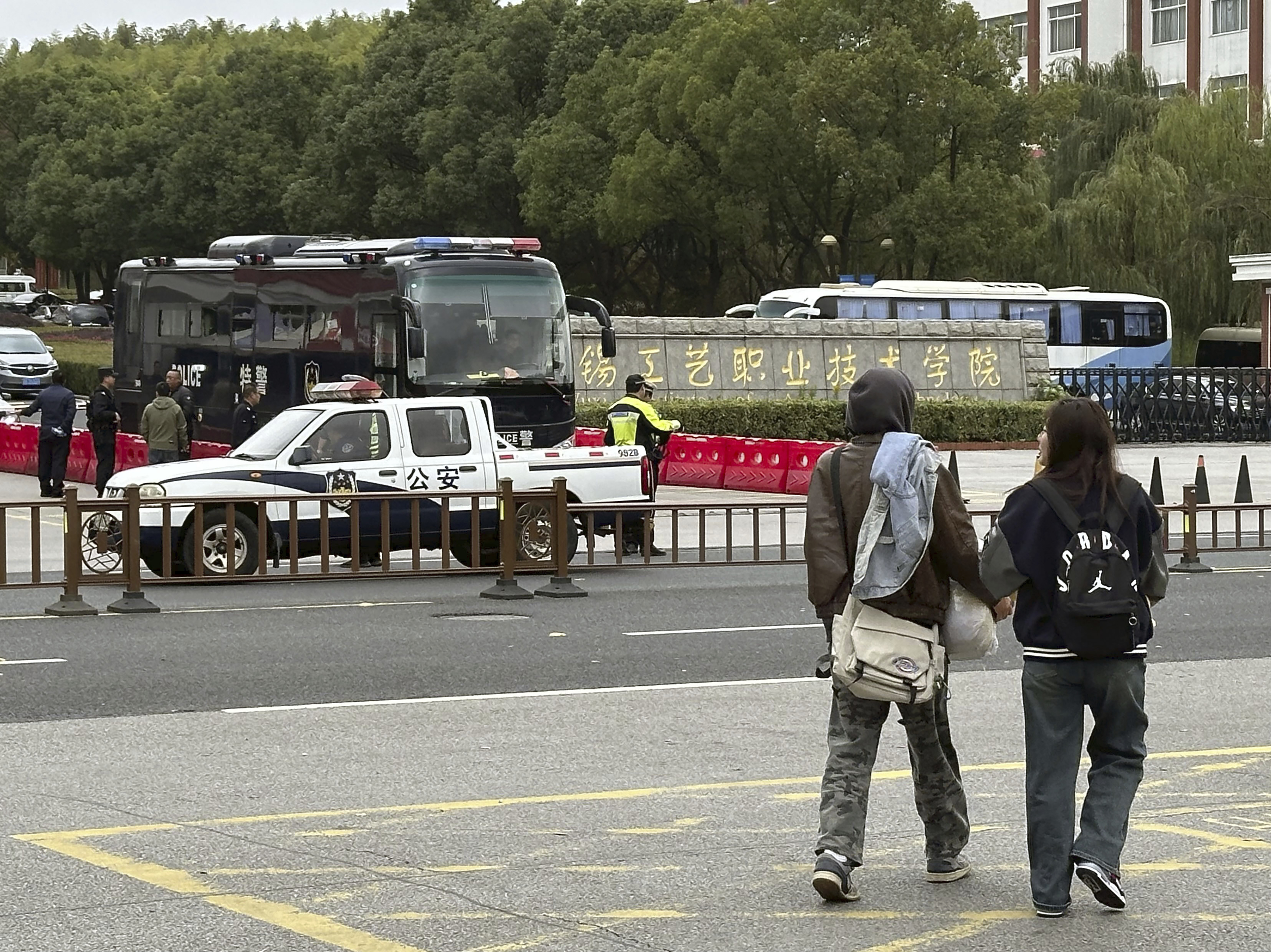 Police vehicles part in front of the Wuxi Vocational Institute of Arts and Technology in Yixing, eastern Chinese city of Wuxi Sunday, Nov. 17, 2024, a day after a stabbing attack took place. (Kyodo News via AP)