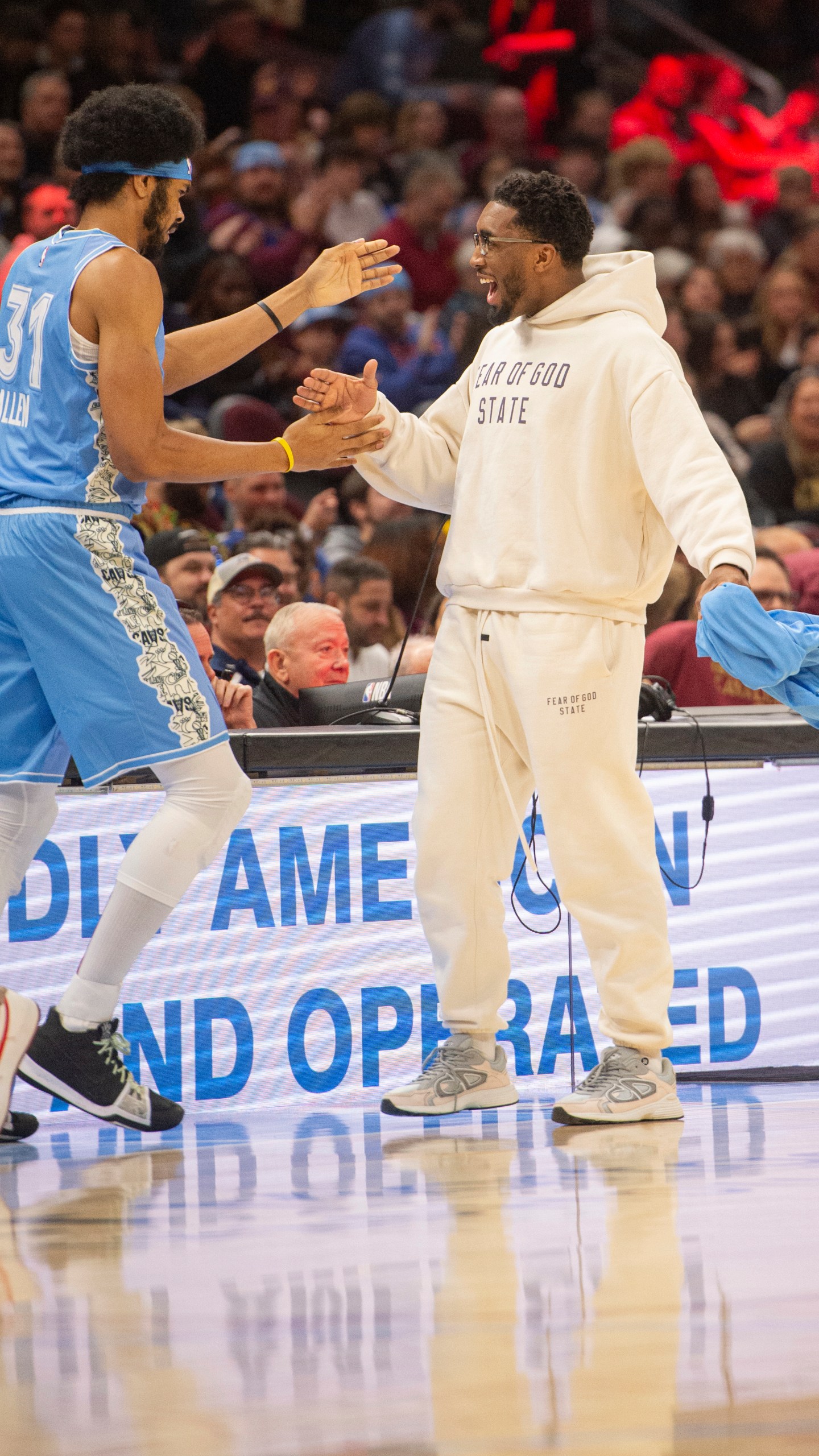 Cleveland Cavaliers' Jarrett Allen (31) is greeted by Donovan Mitchell, right, during the first half of an NBA basketball game against the Charlotte Hornets in Cleveland, Sunday, Nov 17, 2024. Mitchell did not play in the game. (AP Photo/Phil Long)