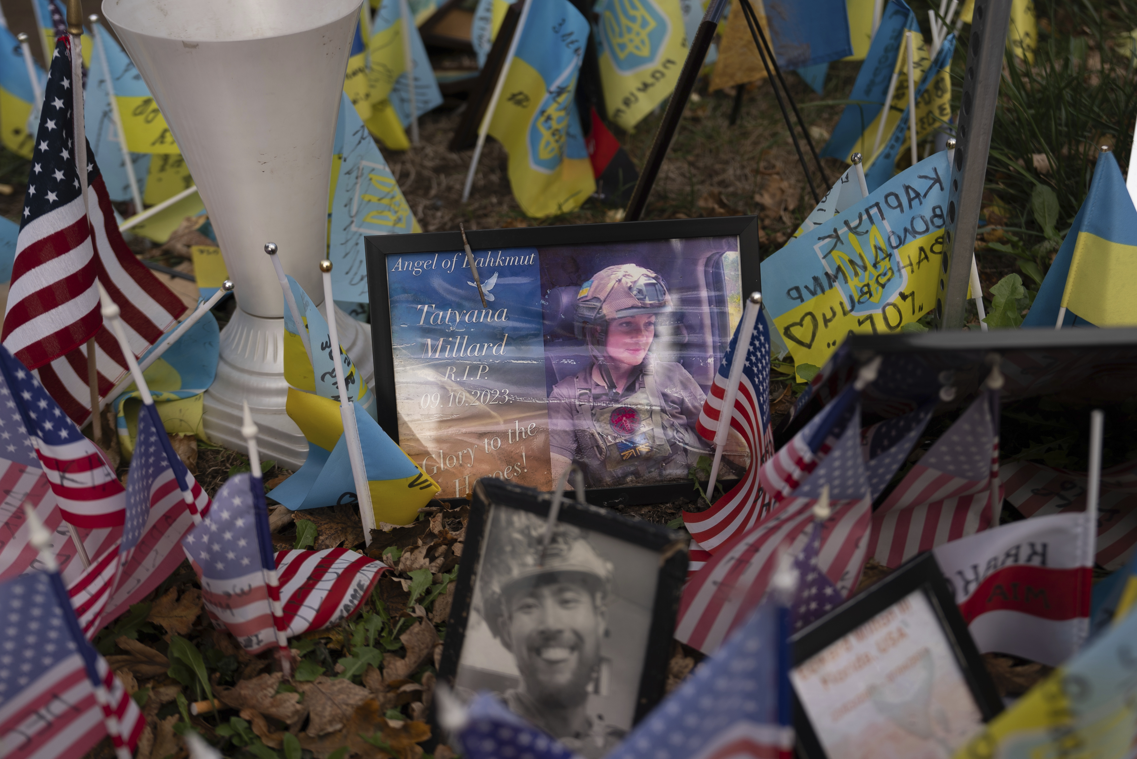 The memorial plate for Tatyana Millard, American volunteer, is seen among Ukrainian and American flags placed in honour of fallen servicemen in Independence Square in central Kyiv, Ukraine, Tuesday, Nov. 5, 2024. (AP Photo/Alex Babenko)