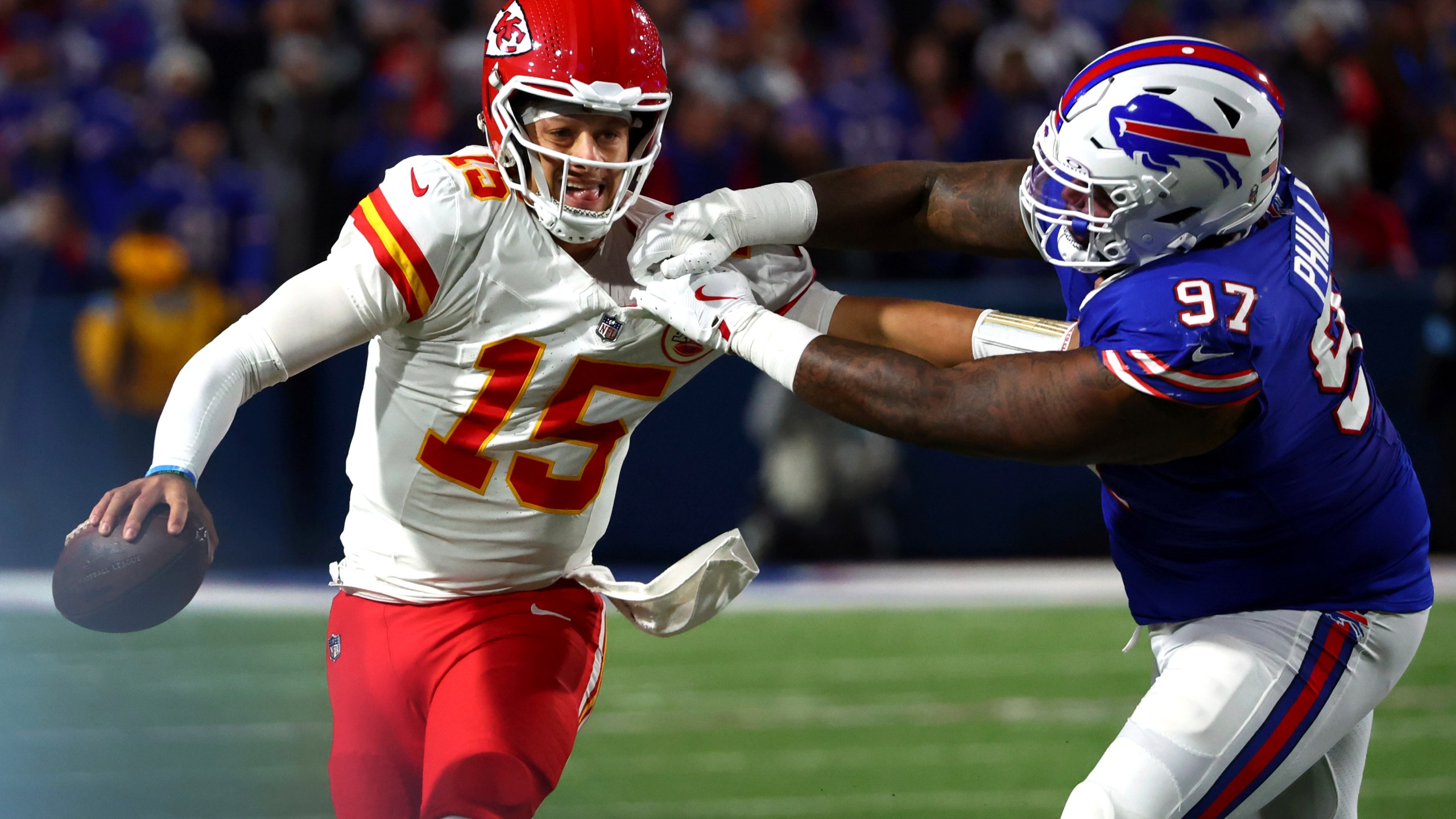 Kansas City Chiefs quarterback Patrick Mahomes (15) scrambles away from Buffalo Bills defensive tackle Jordan Phillips (97) during the second half of an NFL football game Sunday, Nov. 17, 2024, in Orchard Park, N.Y. (AP Photo/Jeffrey T. Barnes)