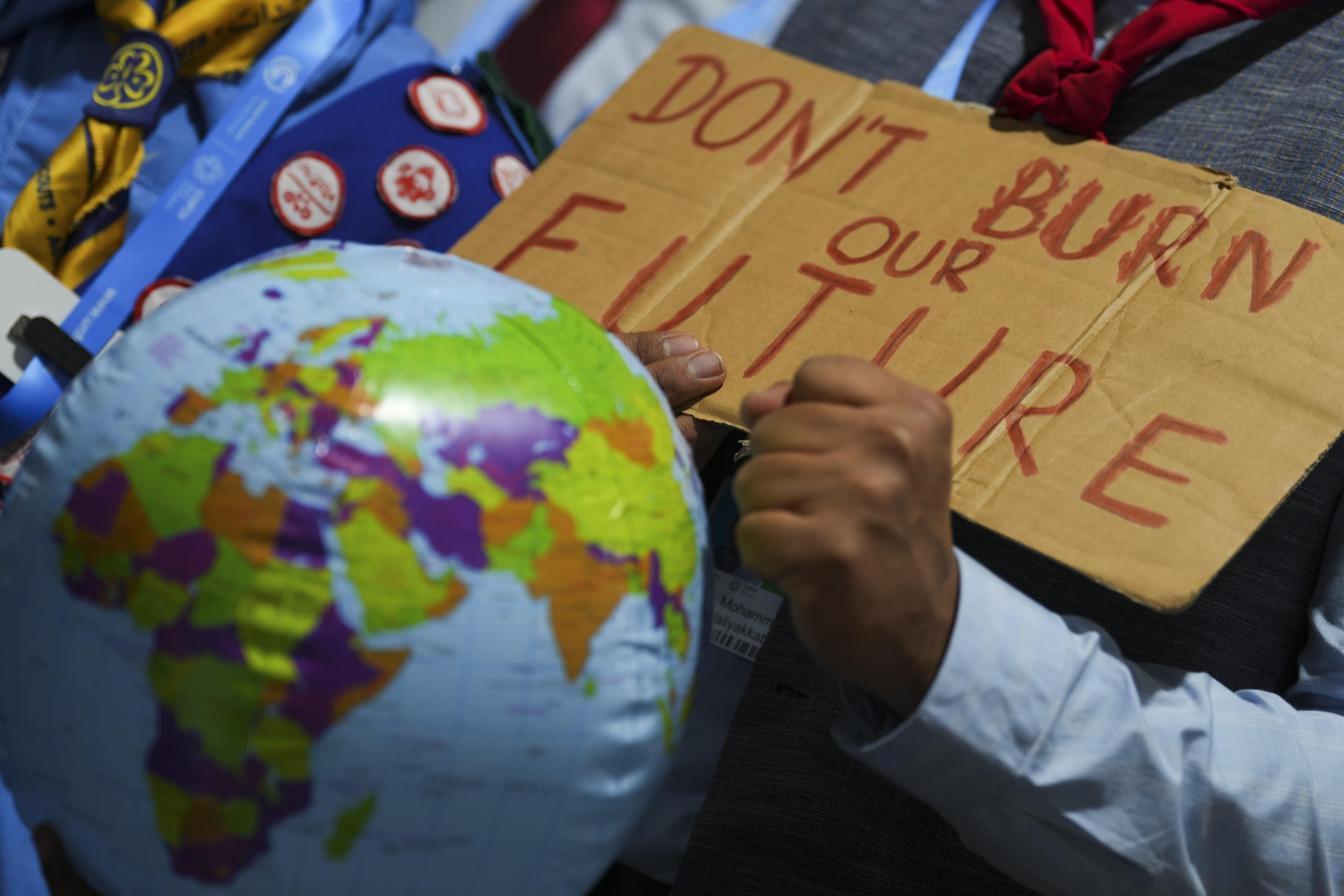 A demonstrators holds a sign that reads "don't burn our future" at the COP29 U.N. Climate Summit, Monday, Nov. 18, 2024, in Baku, Azerbaijan. (AP Photo/Peter Dejong)