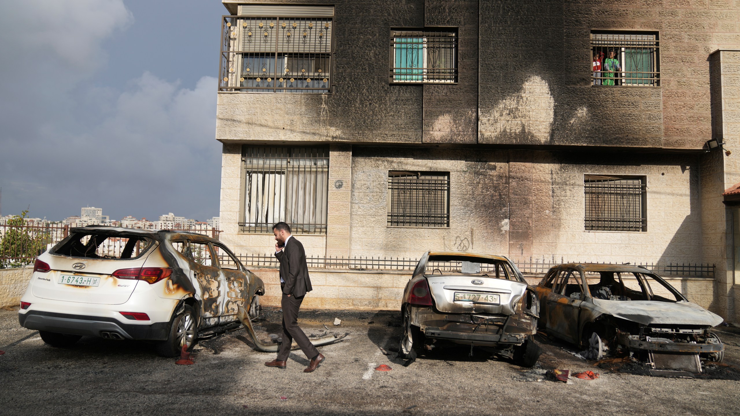 Palestinians inspect vehicles that were burnt during an early morning attack by Israeli settlers, that left at least 18 burnt vehicles, on the outskirts of the West Bank city of al-Bireh Monday, Nov. 4, 2024. (AP Photo/Nasser Nasser)