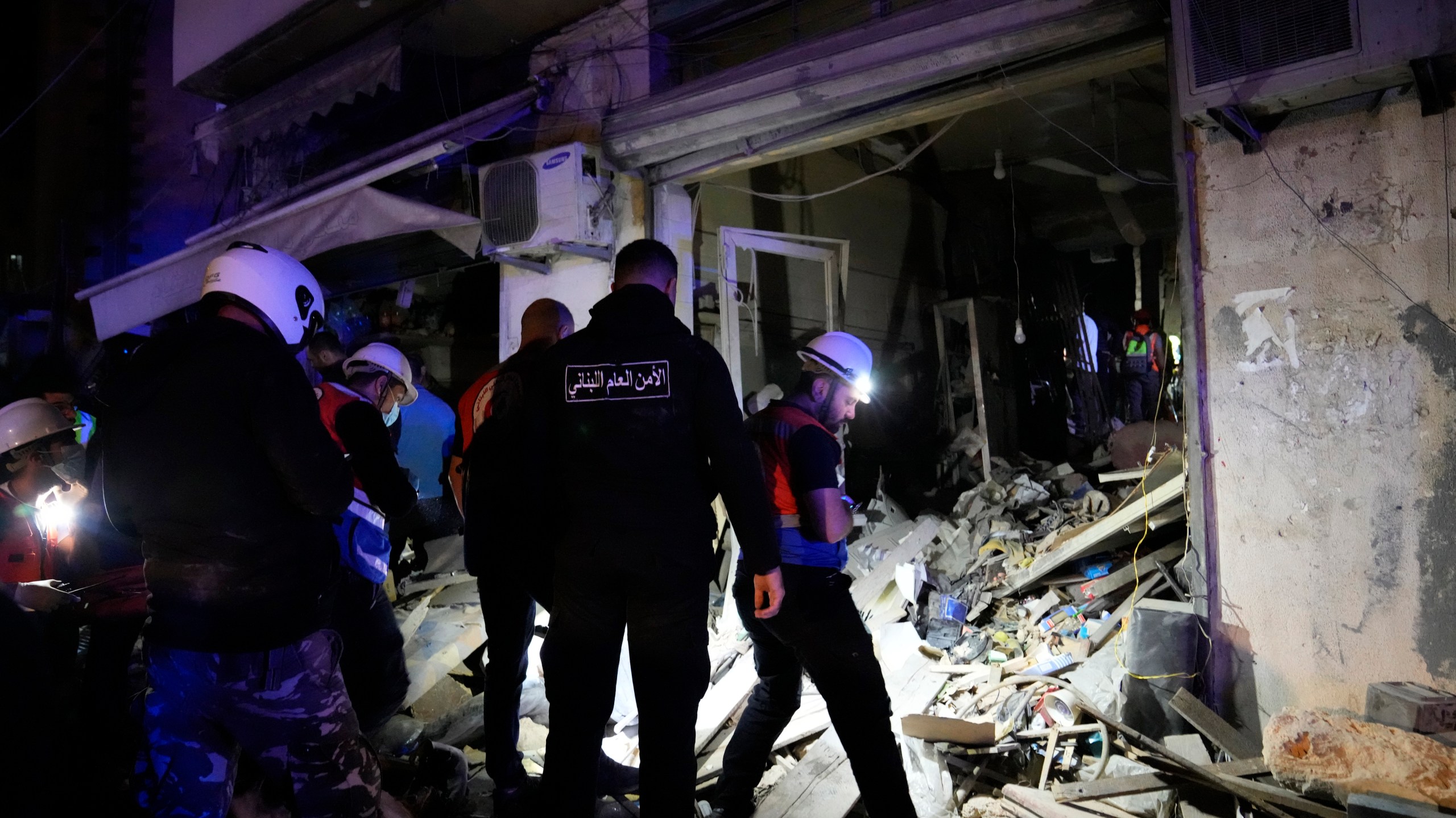 Rescue workers and policemen search for victims at the site of an Israeli airstrike in Beirut, Lebanon, Monday, Nov. 18, 2024. (AP Photo/Hussein Malla)