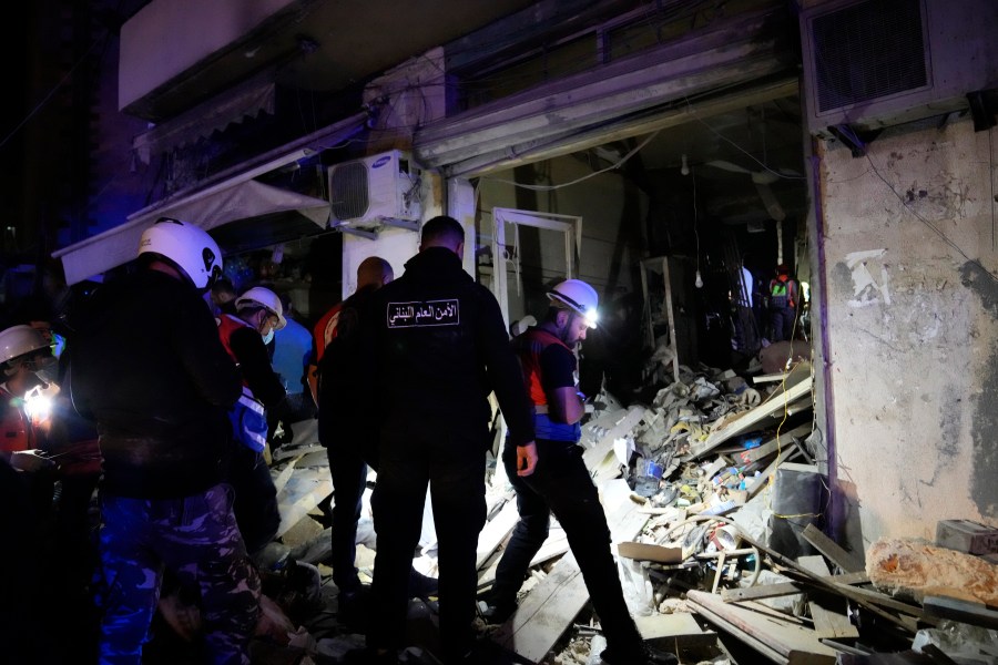 Rescue workers and policemen search for victims at the site of an Israeli airstrike in Beirut, Lebanon, Monday, Nov. 18, 2024. (AP Photo/Hussein Malla)