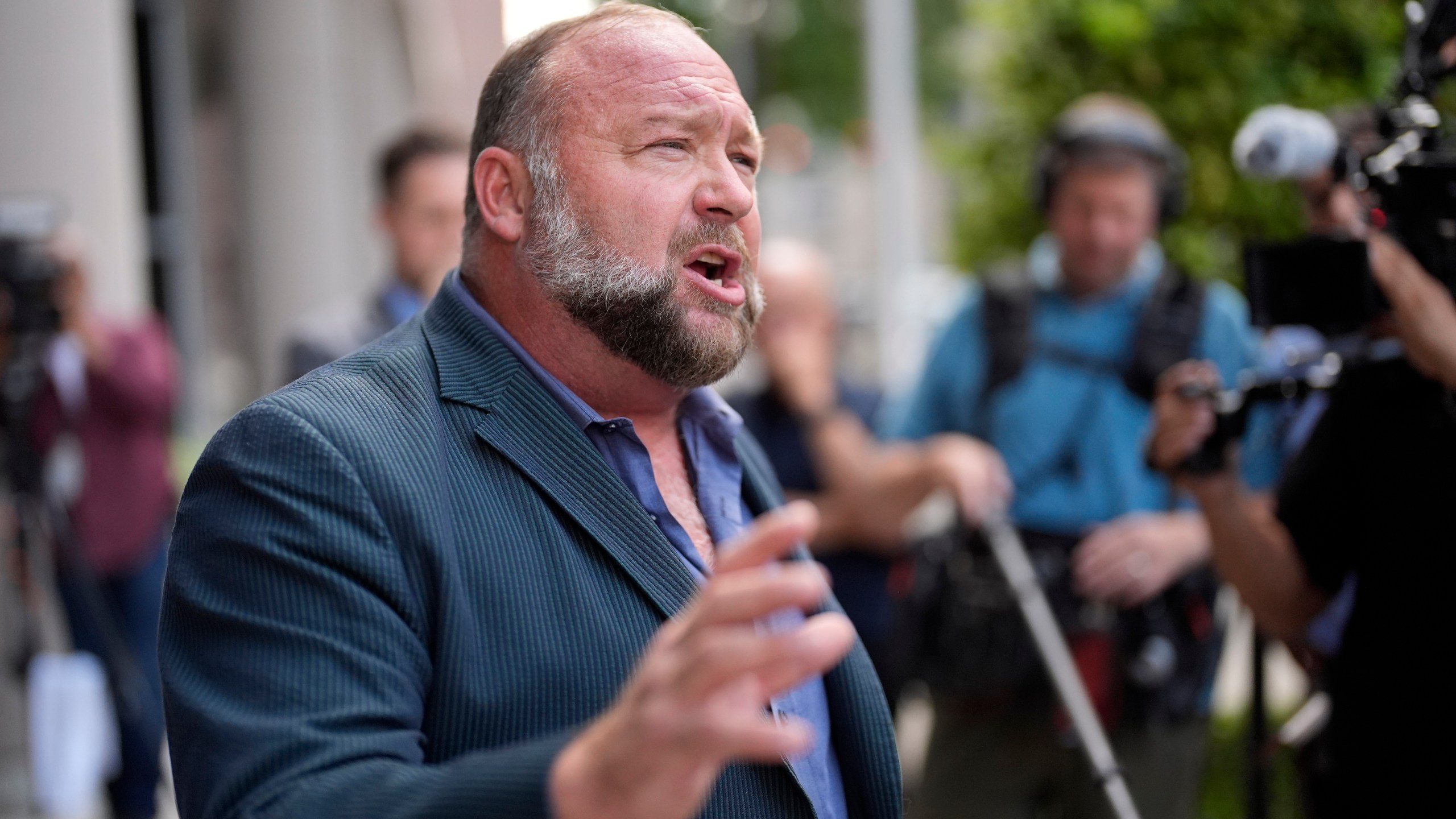 FILE - Right-wing conspiracy theorist Alex Jones speaks to the media after arriving at the federal courthouse for a hearing in front of a bankruptcy judge, Friday, June 14, 2024, in Houston. (AP Photo/David J. Phillip, File)