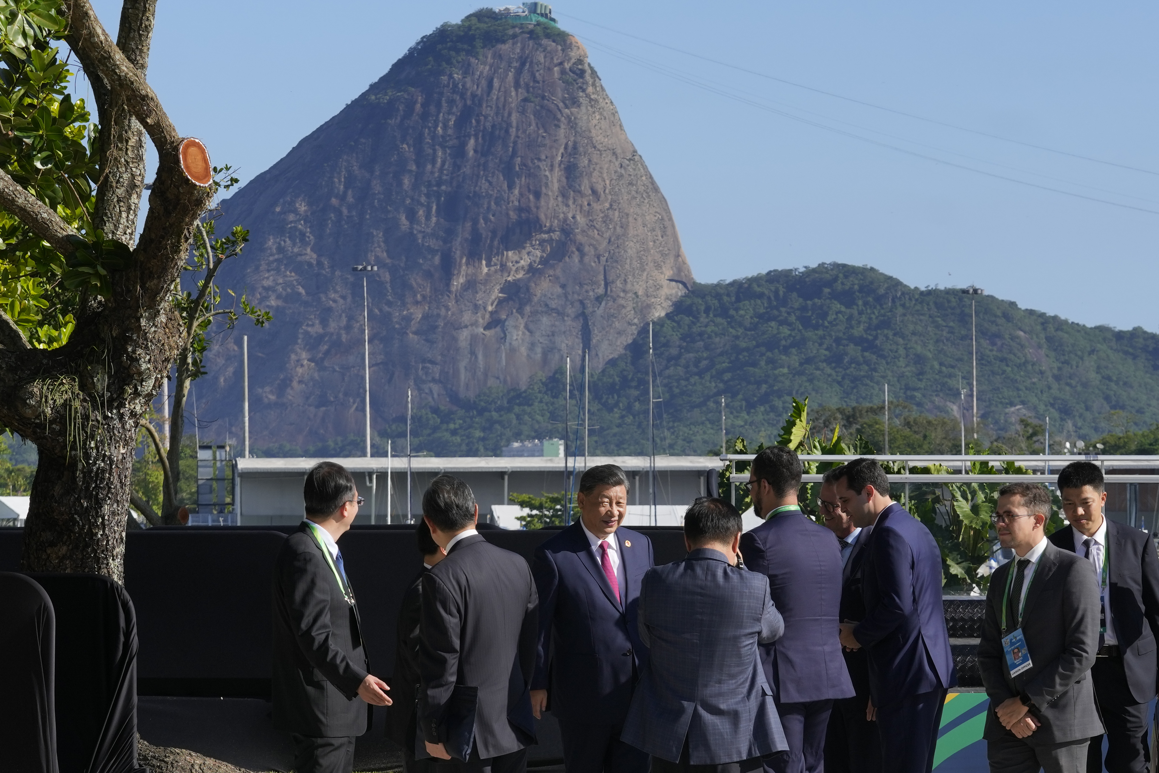 Backdropped by Sugar Loaf mountain, China's President Xi Jinping, center, walks after joining a group photo during the G20 Summit in Rio de Janeiro, Monday, Nov. 18, 2024. (AP Photo/Eraldo Peres)