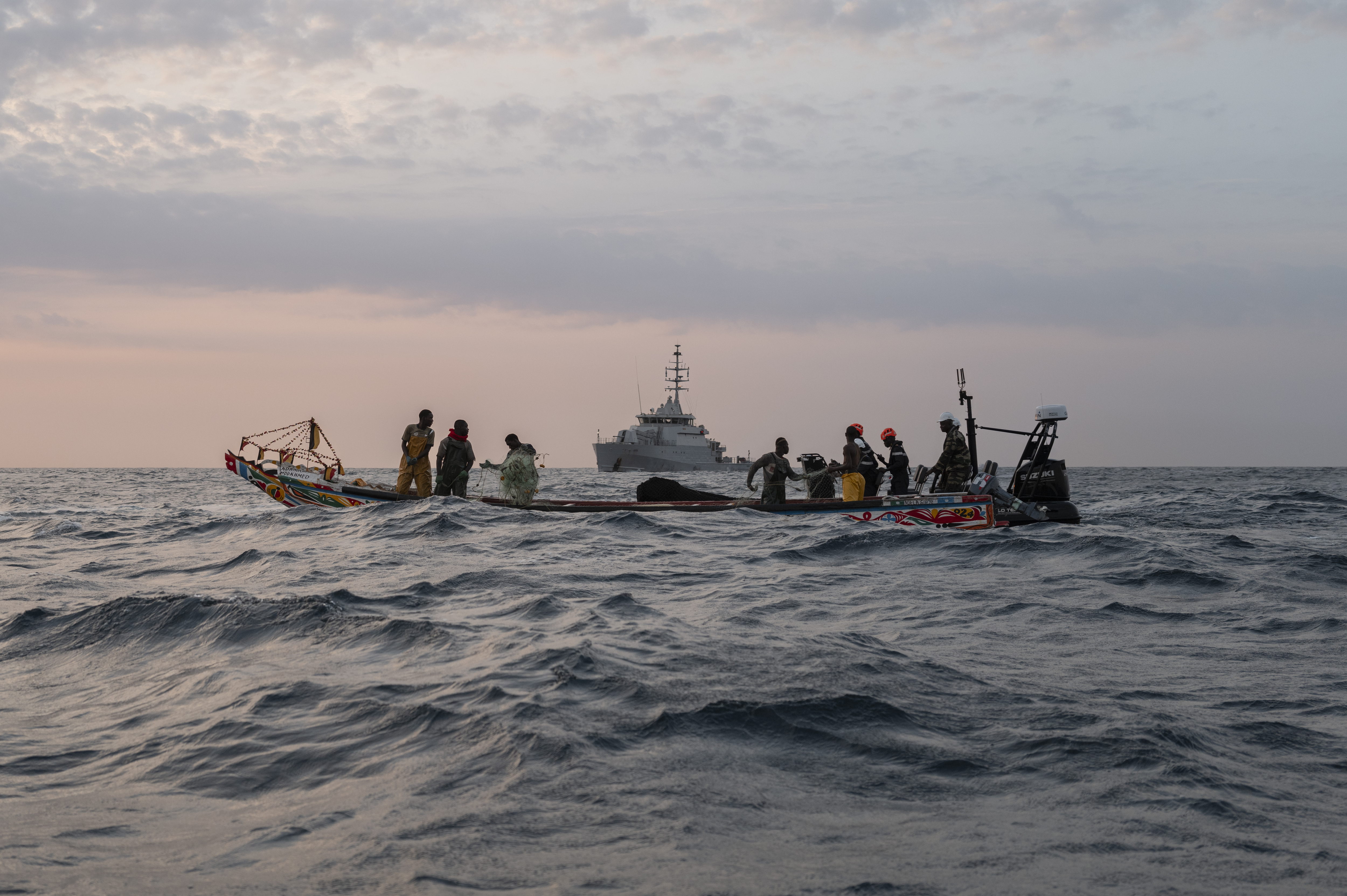 Senegalese sailors in their zodiac, background, approach a fishermen's pirogue to check during a mission to search for illegal migrant boats near the coast of Dakar, Senegal, Saturday, Nov.16, 2024. (AP Photo/Sylvain Cherkaoui)