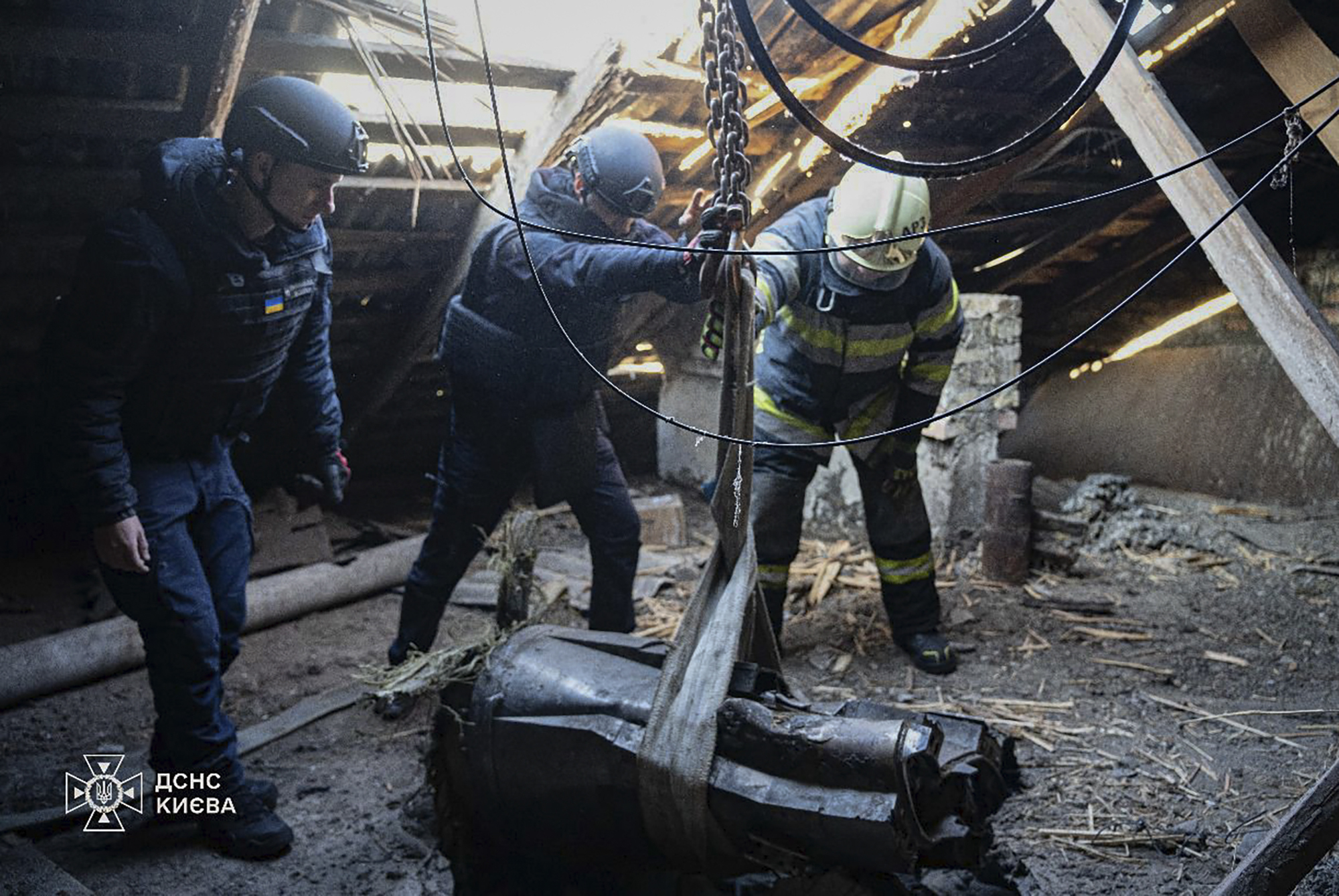 In this photo provided by the Ukrainian Emergency Service, emergency services personnel remove part of a Russian missile that hit an apartment house during massive missile attack in Kyiv, Ukraine, Sunday, Nov. 17, 2024. (Ukrainian Emergency Service via AP)