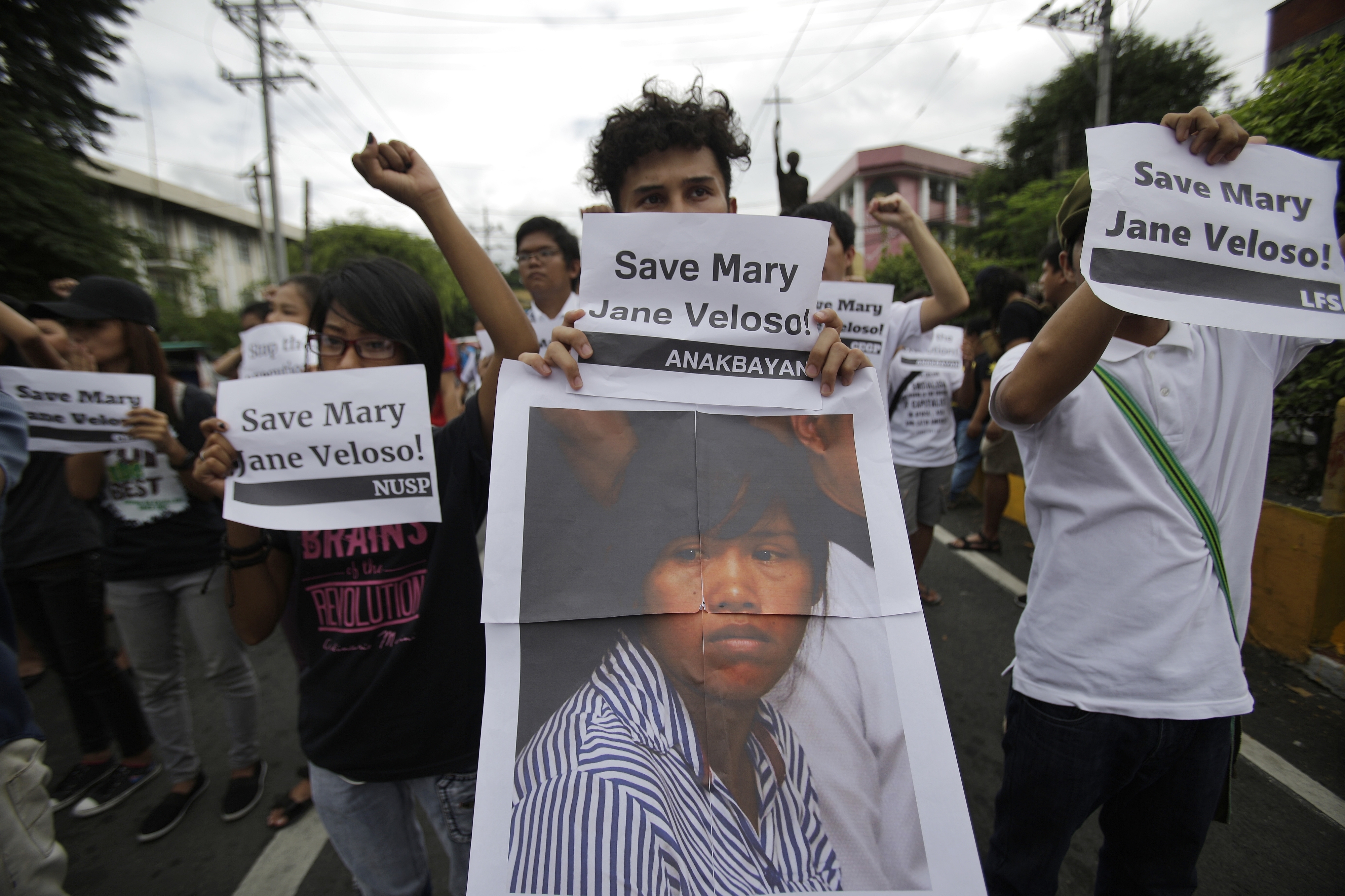 FILE - Protesters hold a picture of Mary Jane Veloso, a Filipino convicted drug trafficker in Indonesia, as they urge Philippine President save her from execution during a rally in Manila, Philippines on Tuesday, Sept. 13, 2016. (AP Photo/Aaron Favila, File)