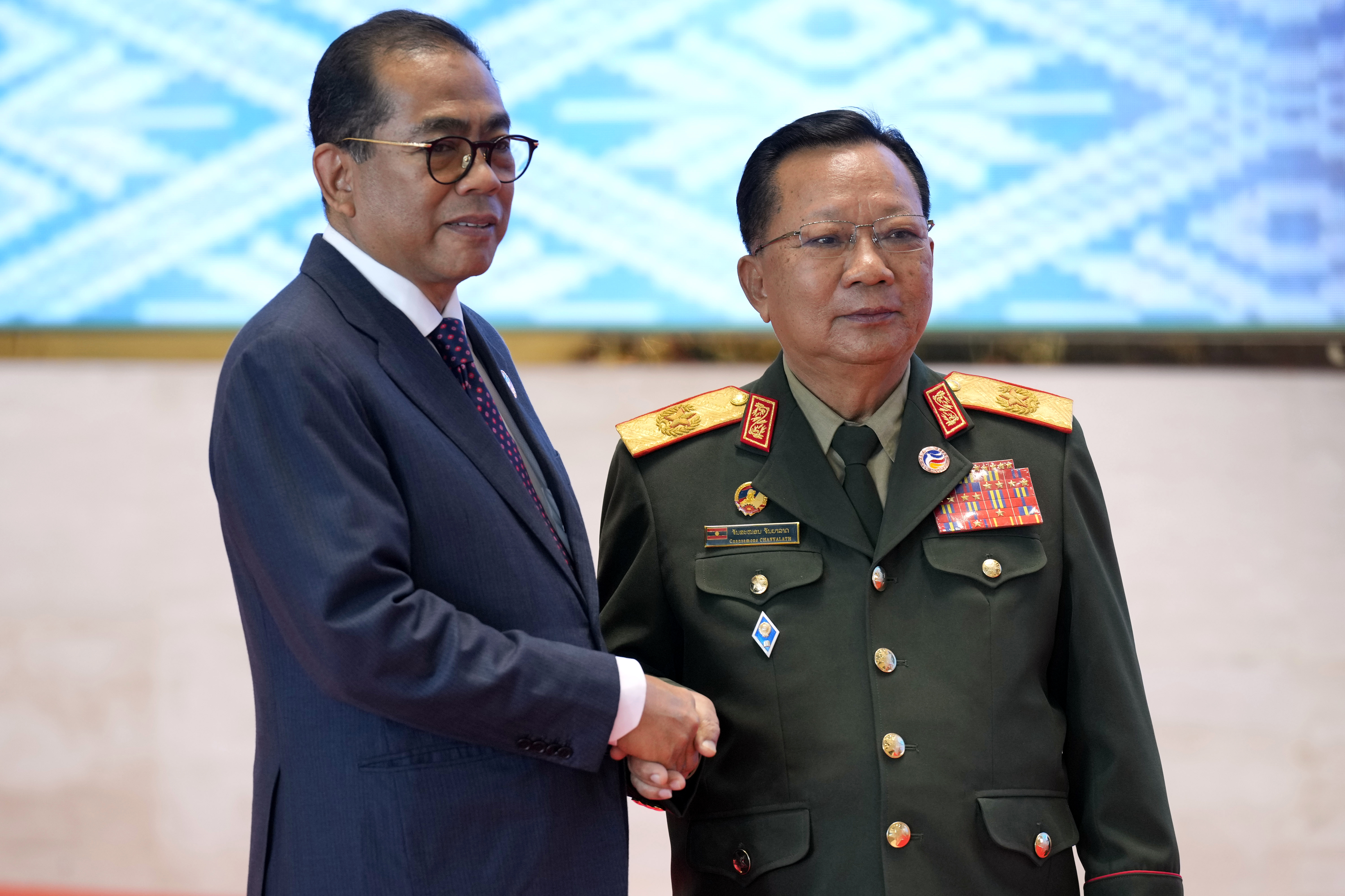 Laos' Defense Minister Chansamone Chanyalath, right, greets Malaysian Defence Minister Mohamed Khaled Nordin during the Association of Southeast Asian Nations (ASEAN) defense ministers' meeting in Vientiane, Laos, Wednesday, Nov. 20, 2024. (AP Photo/Anupam Nath)