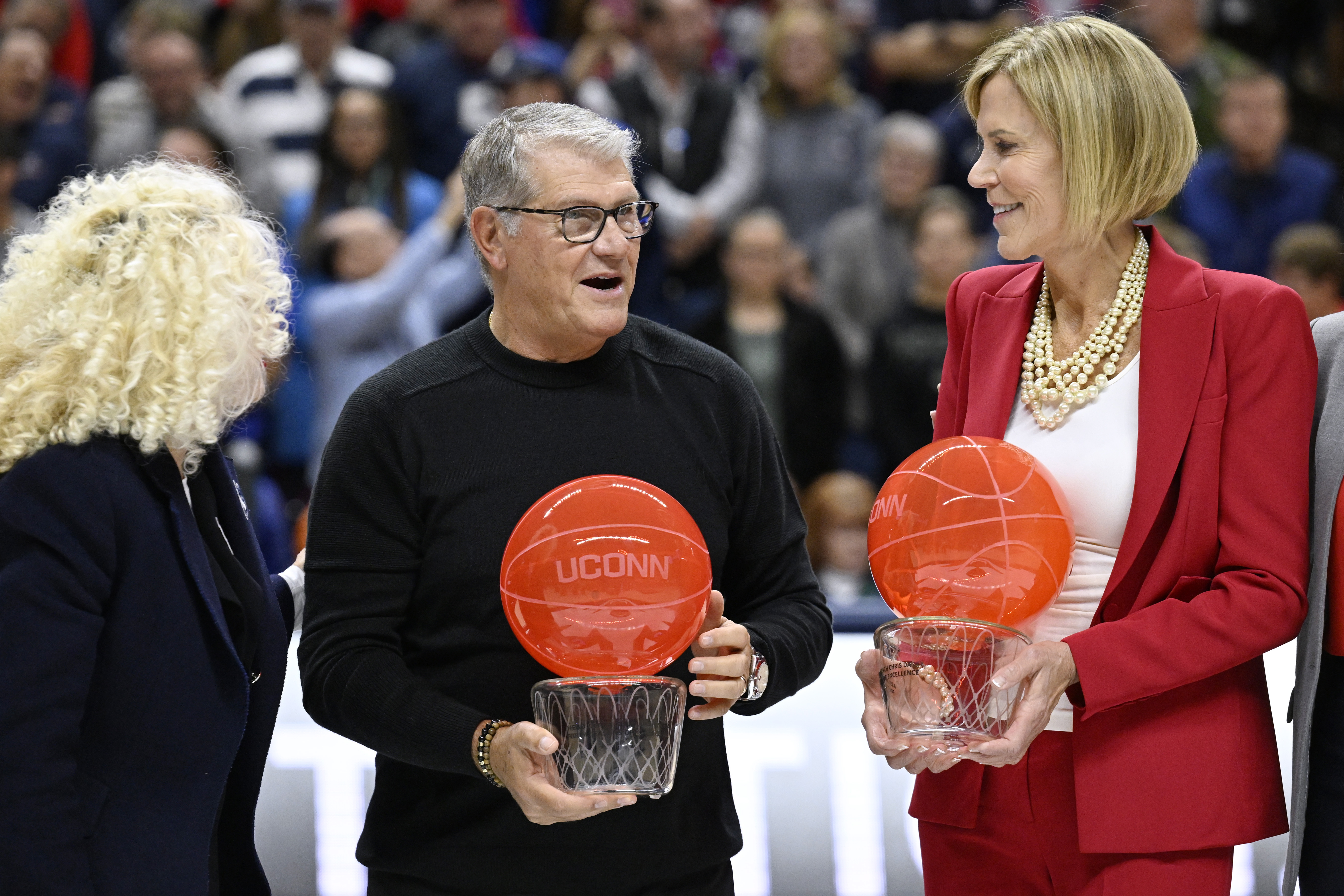 UConn head coach Geno Auriemma and associate head coach Chris Dailey receive recognition from UConn president Radenka Maric, left, during a pregame ceremony honoring Auriemma and longtime assistant Chris Dailey, Wednesday, Nov. 20, 2024, in Storrs, Conn. (AP Photo/Jessica Hill)