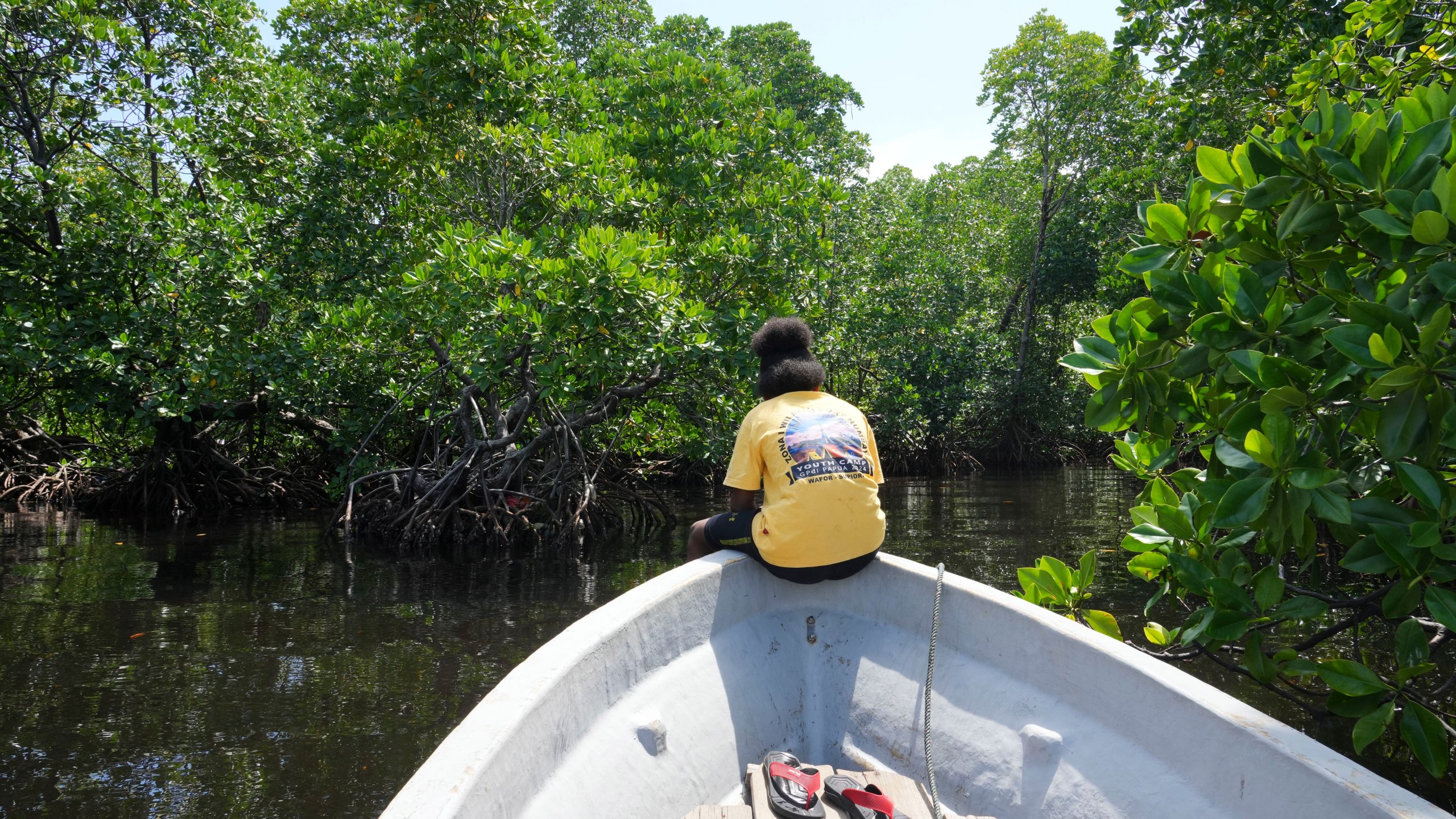 Martha Tjoe sits on a boat through a mangrove forest where only women are permitted to enter in Jayapura, Papua province, Indonesia on Wednesday, Oct. 2, 2024. (AP Photo/Firdia Lisnawati)