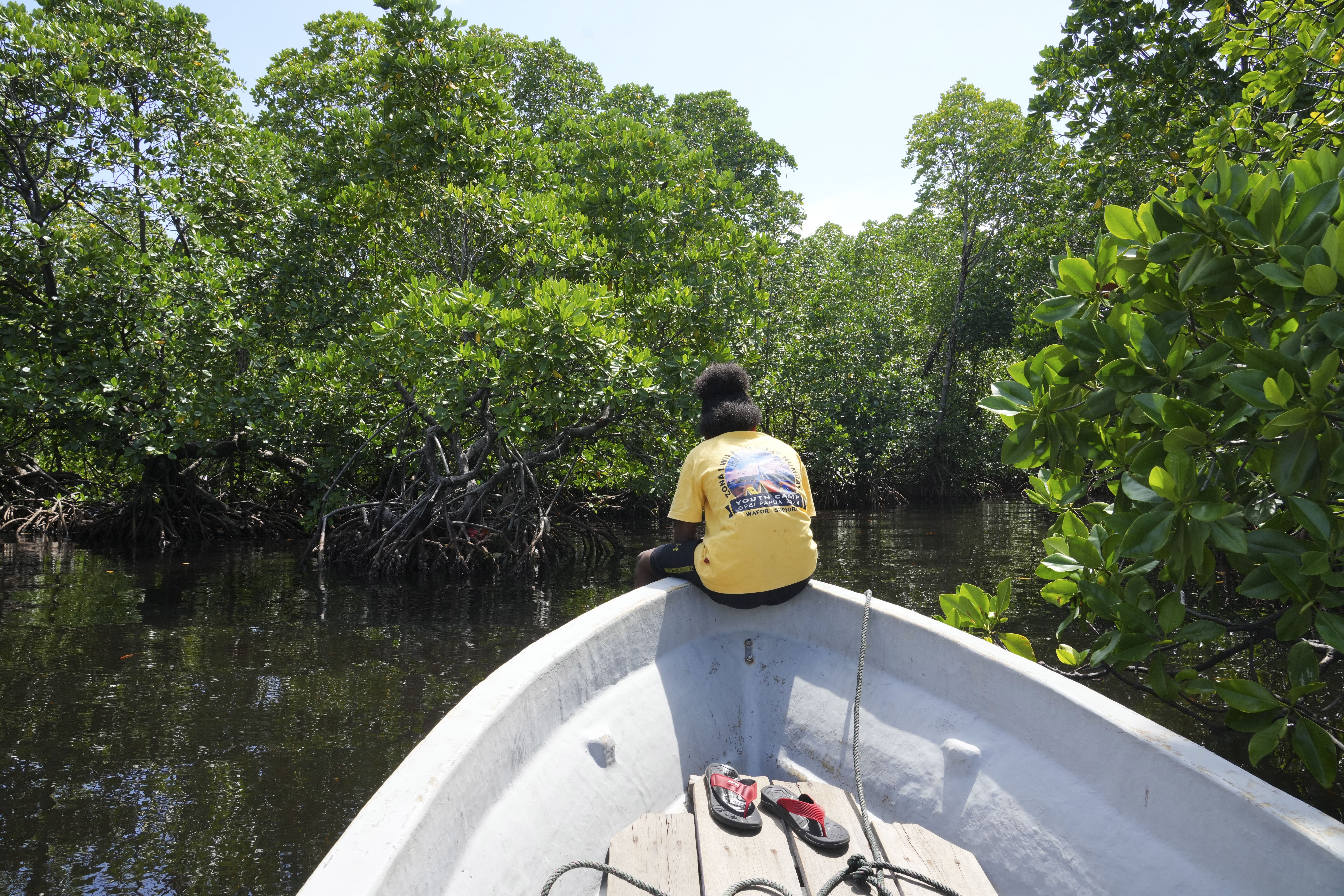 Martha Tjoe sits on a boat through a mangrove forest where only women are permitted to enter in Jayapura, Papua province, Indonesia on Wednesday, Oct. 2, 2024. (AP Photo/Firdia Lisnawati)