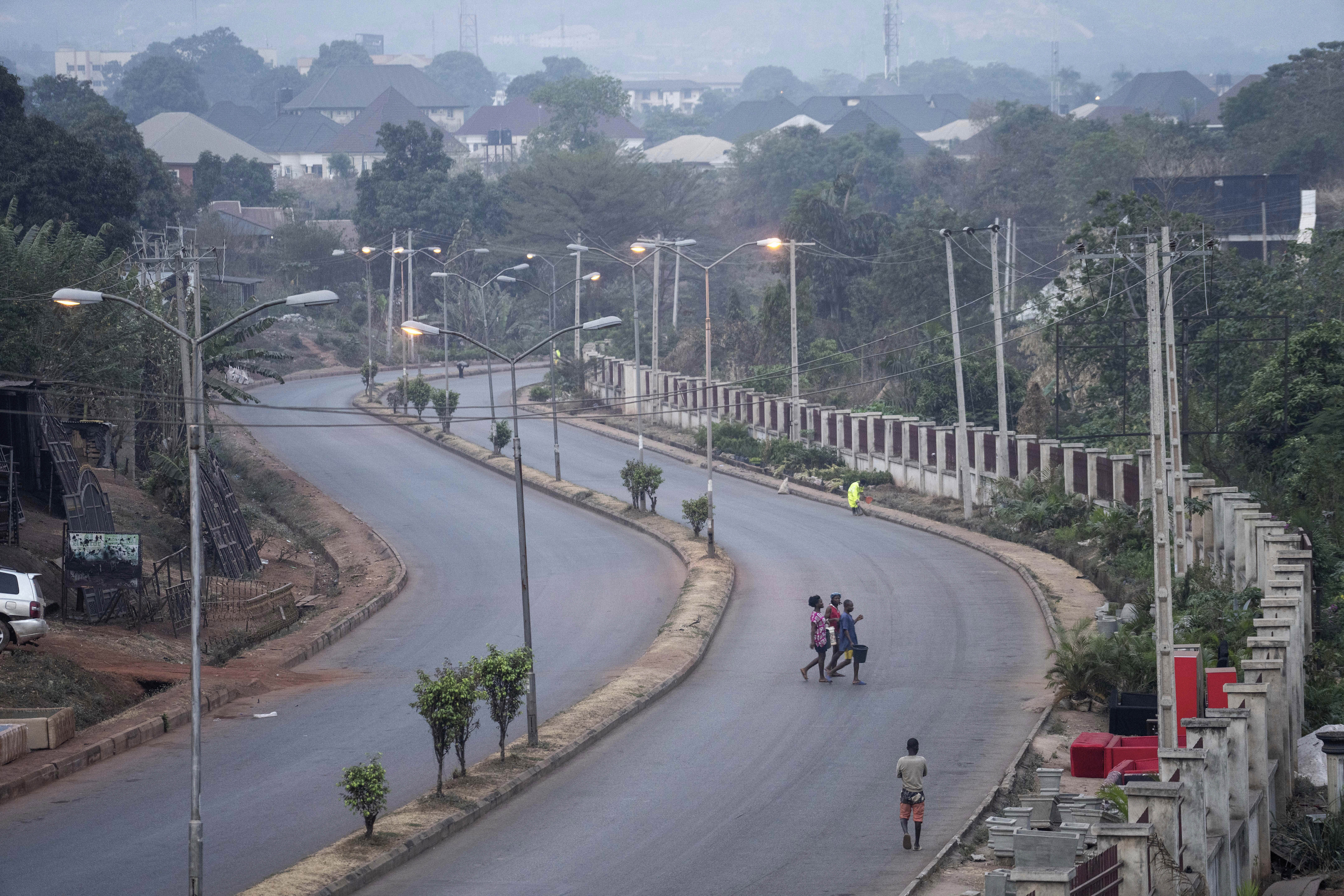 FILE - People walk across a normally packed highway during a separatists imposed lockdown in Enugu, Nigeria, Feb. 14, 2022. (AP Photo/Jerome Delay, File)