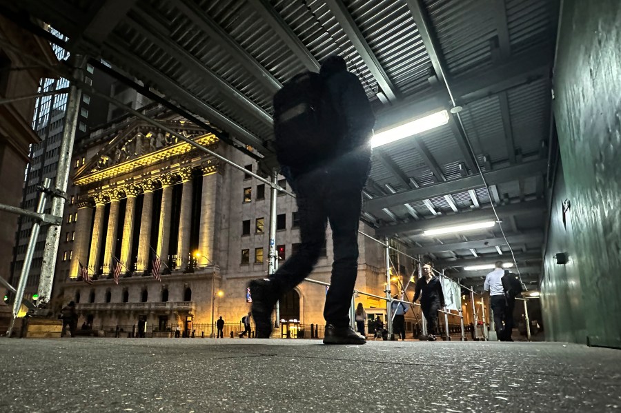 FILE - People walk under a sidewalk shed near the New York Stock Exchange on Oct. 30, 2024. (AP Photo/Peter Morgan, File)