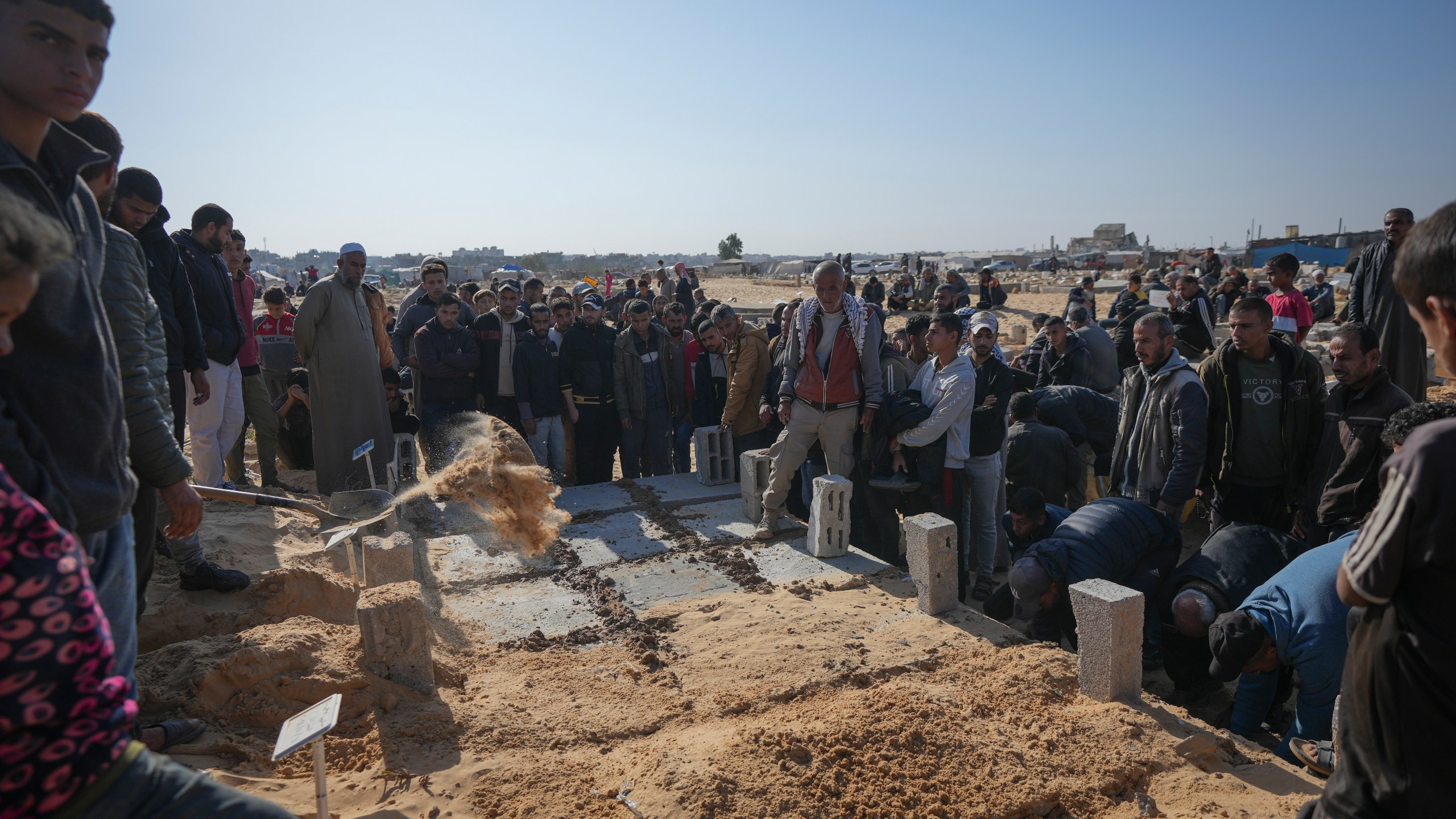 The graves of three children from the same family killed during an Israeli army strike are covered during their burial in Khan Younis, Gaza Strip, Thursday Nov. 21, 2024. Seven-year-old Hamza, his five-year-old brother Abdelaziz, and his four-year-old sister Laila Hassan were among 9 people killed by an Israeli strike in Khan Younis on Wednesday. Palestinian health officials say the death toll in the Gaza Strip from the 13-month-old war between Israel and Hamas has surpassed 44,000. (AP Photo/Abdel Kareem Hana)