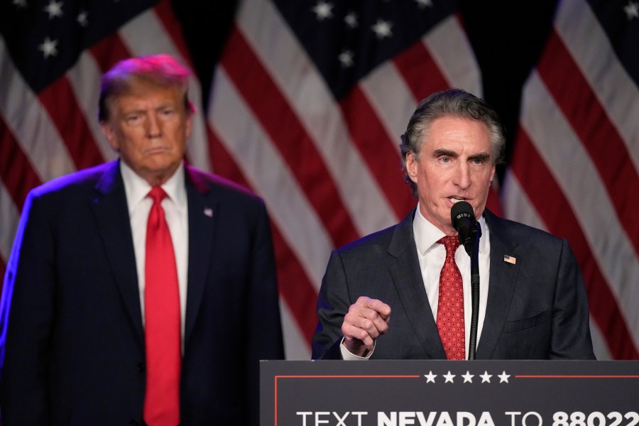 FILE - Republican presidential candidate former President Donald Trump listens as North Dakota Gov. Doug Burgum speaks at a caucus night rally in Las Vegas, Feb. 8, 2024. (AP Photo/Mark J. Terrill, File)