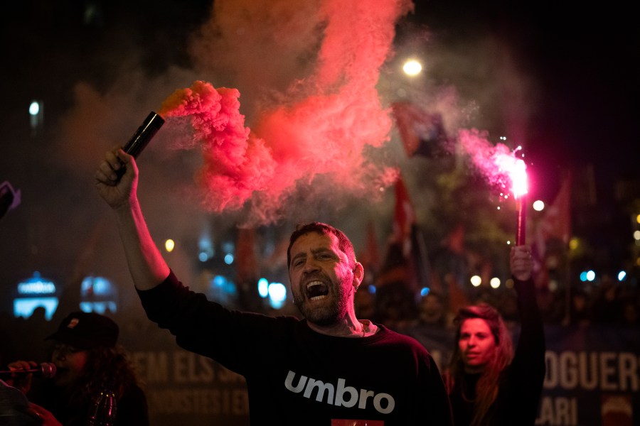 Demonstrators light flares while marching in a protest against the exorbitant rise in the price of renting an apartment in Barcelona, Spain, Saturday, Nov. 23, 2024. (AP Photo/Emilio Morenatti)