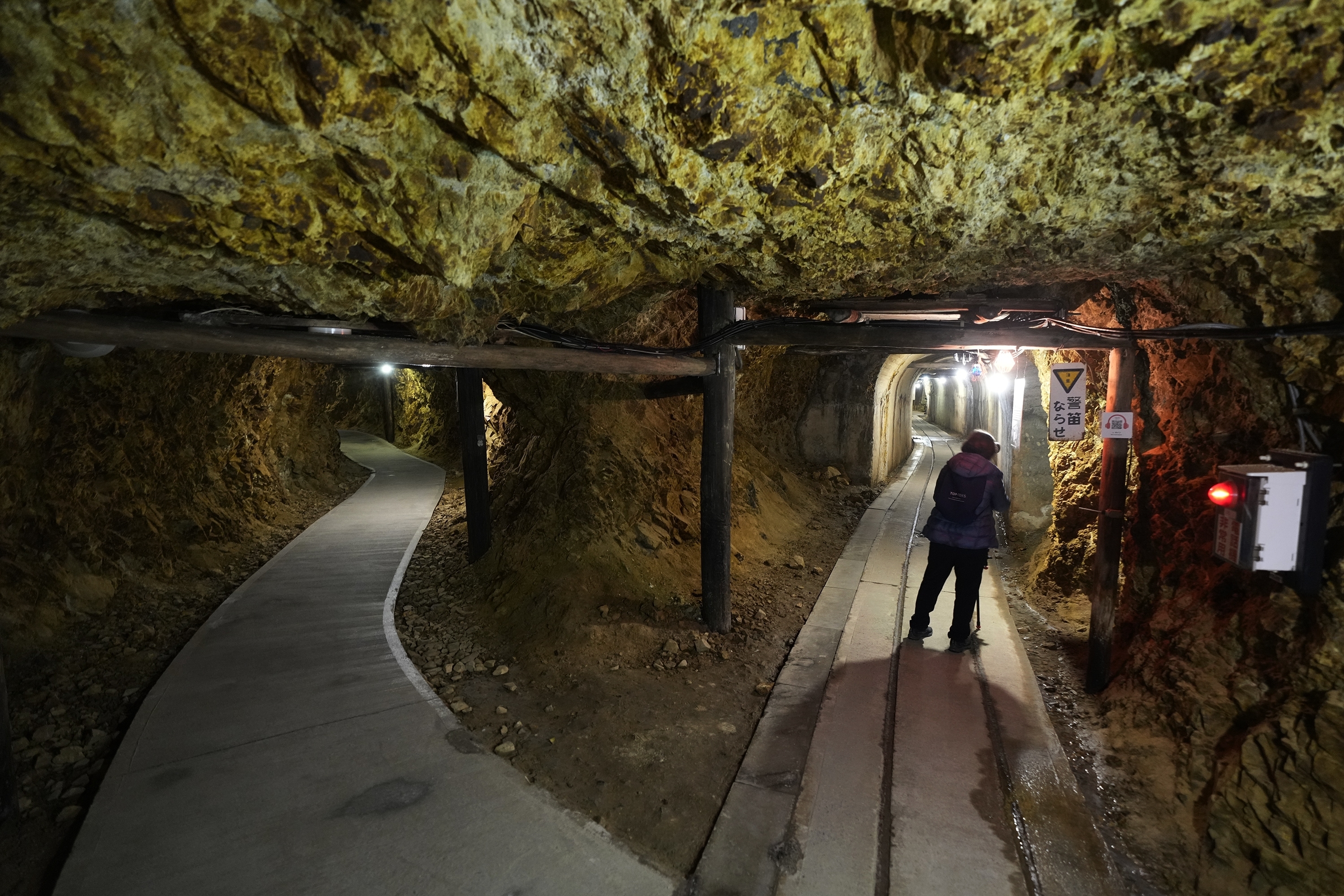 A visitor walk through tunnels at Sado Kinzan Gold Mine historic site in Sado, Niigata prefecture, Japan, Sunday, Nov. 24, 2024. (AP Photo/Eugene Hoshiko)