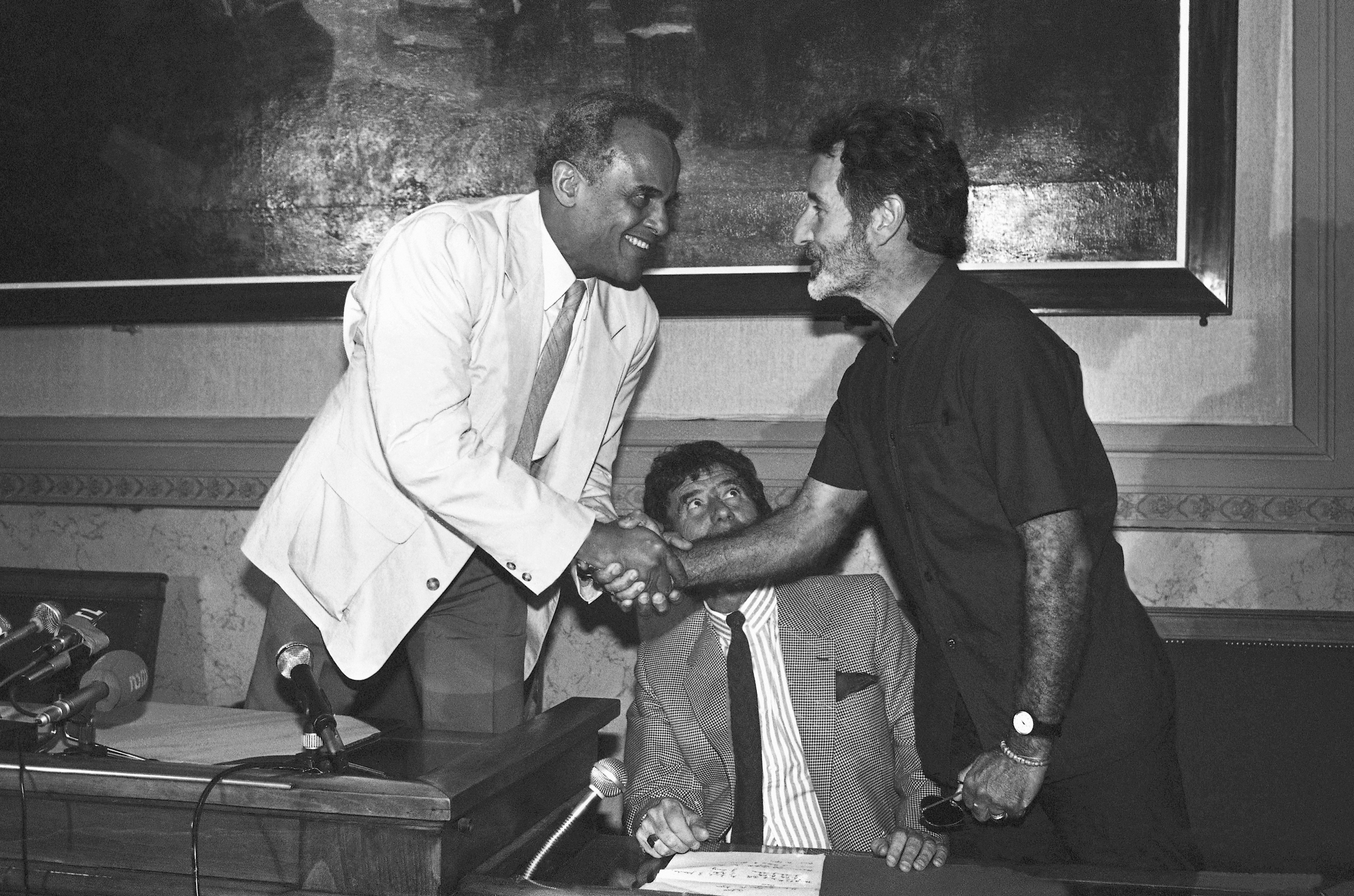 FILE - South African writer Breyten Breytenbach, right, and American actor and singer Harry Belafonte shake hands during a press conference in Paris, on June 18, 1986. (AP Photo, File)