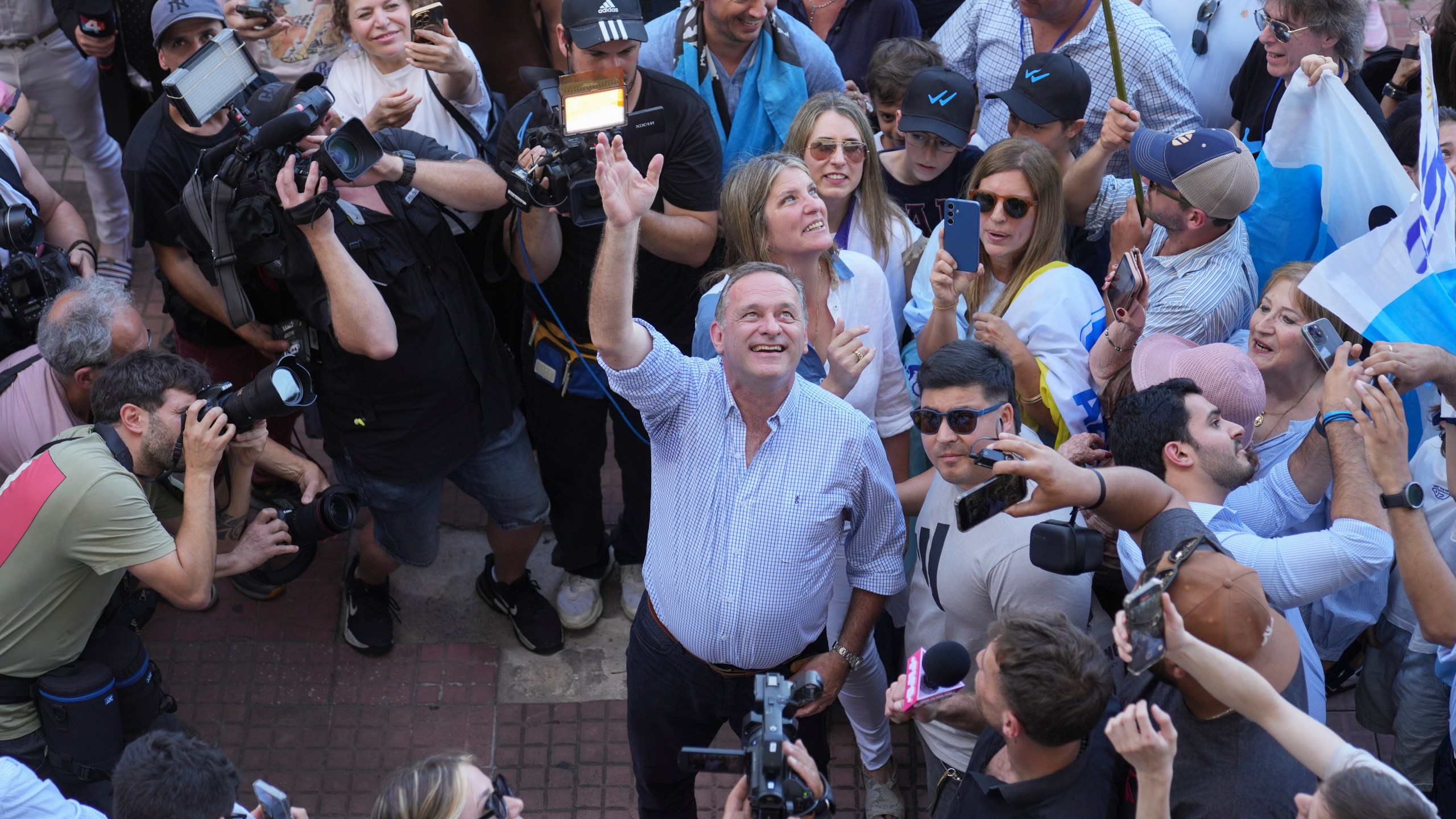 Alvaro Delgado, candidate for the ruling National Party, waves after voting in the presidential run-off election in Montevideo, Uruguay, Sunday, Nov. 24, 2024. (AP Photo/Natacha Pisarenko)