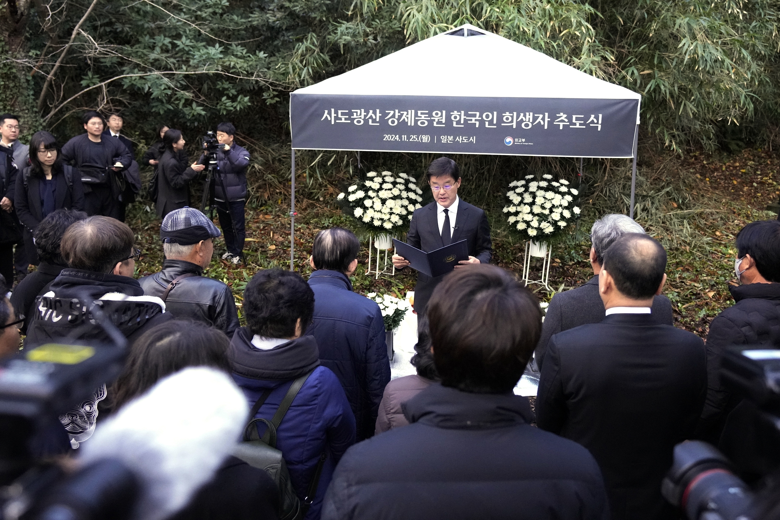 South Korean Ambassador to Japan Park Cheol-hee, center, delivers a speech as relatives of Korean victims and South Korean officials hold a memorial service in Sado, Niigata prefecture, Japan, Monday, Nov. 25, 2024, after boycotting a memorial organized by Japanese officials. (AP Photo/Eugene Hoshiko)