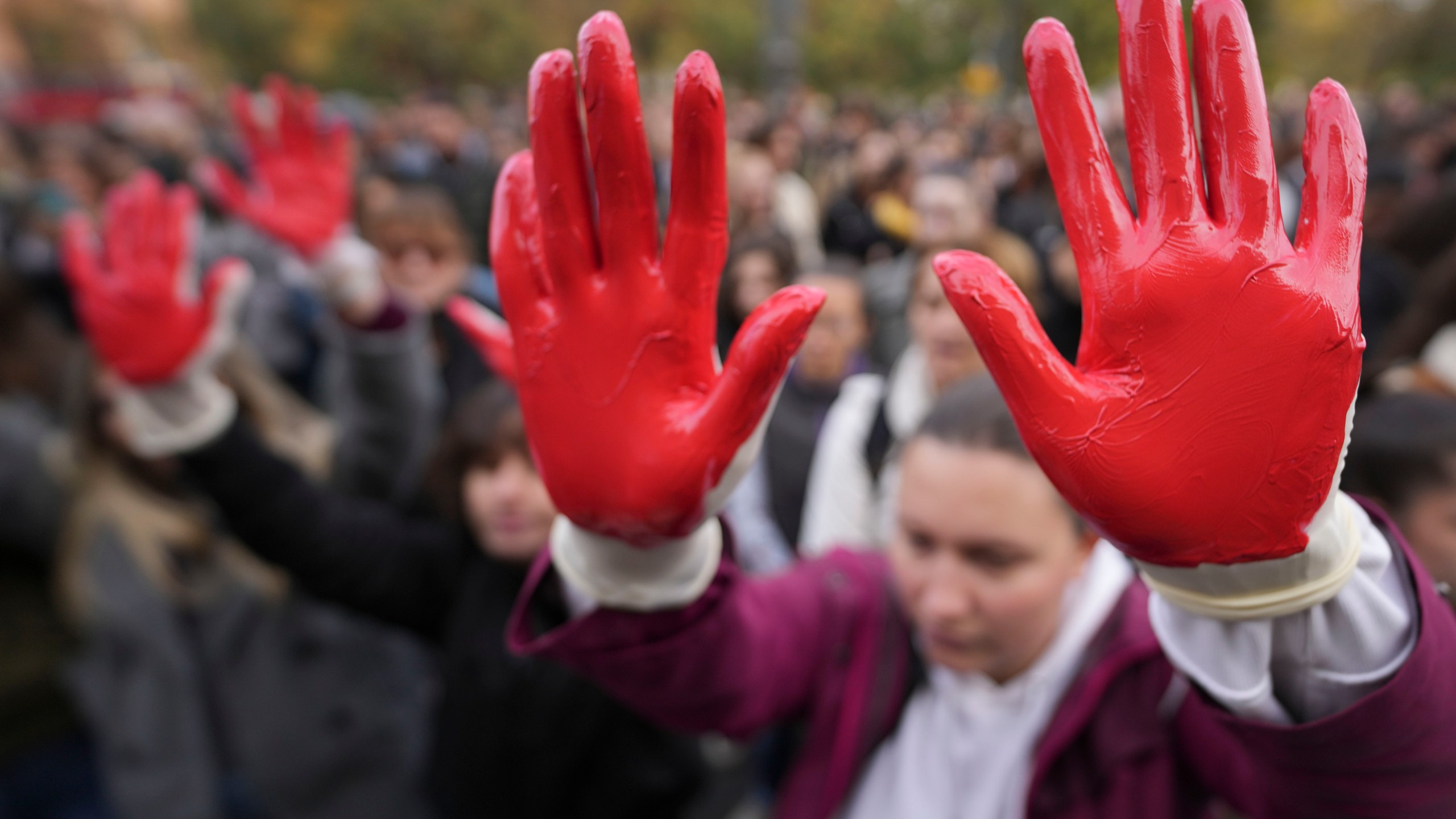 Protesters shout slogans with red paint on the hands symbolizing blood, demand arrests, two days after a concrete canopy collapsed at a railway station in Novi Sad, killing 14 people and injuring three, during protest in Belgrade, Serbia, Sunday, Nov. 3, 2024. (AP Photo/Darko Vojinovic)