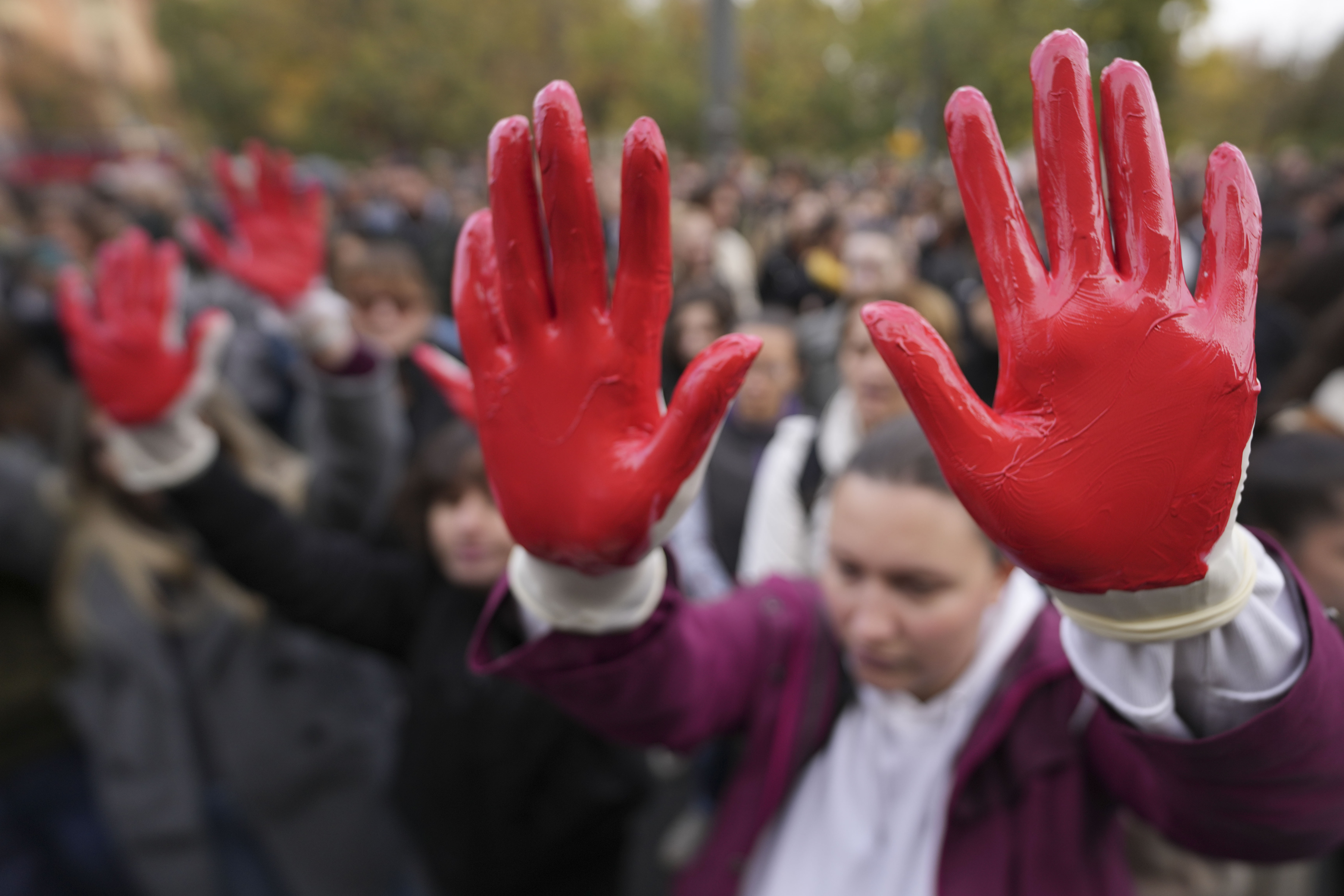 Protesters shout slogans with red paint on the hands symbolizing blood, demand arrests, two days after a concrete canopy collapsed at a railway station in Novi Sad, killing 14 people and injuring three, during protest in Belgrade, Serbia, Sunday, Nov. 3, 2024. (AP Photo/Darko Vojinovic)