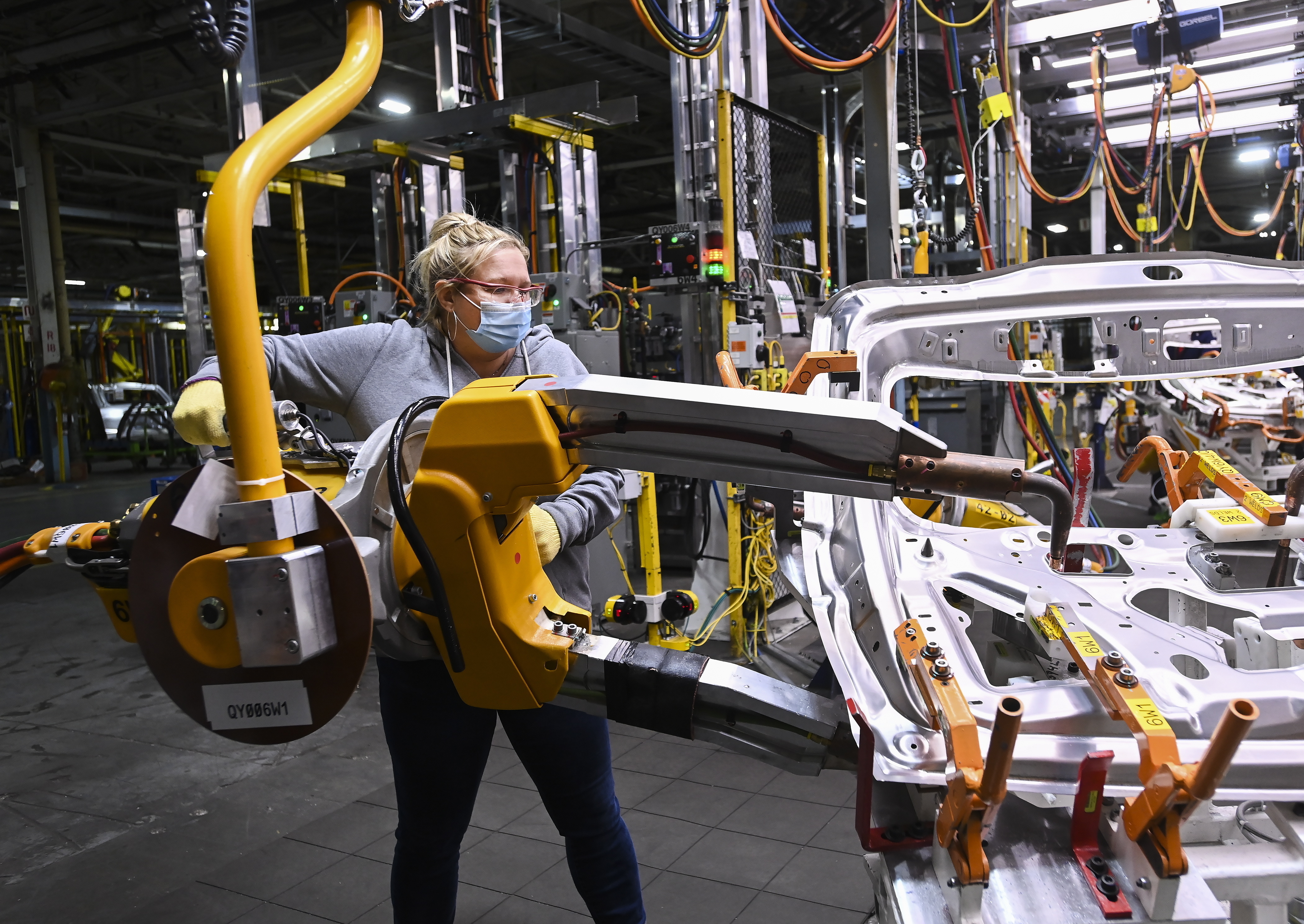 FILE - GM workers use human assistance automation to weld vehicle doors at the General Motors assembly plant during the COVID-19 pandemic in Oshawa, Ontario, March 19, 2021. (Nathan Denette/The Canadian Press via AP, File)