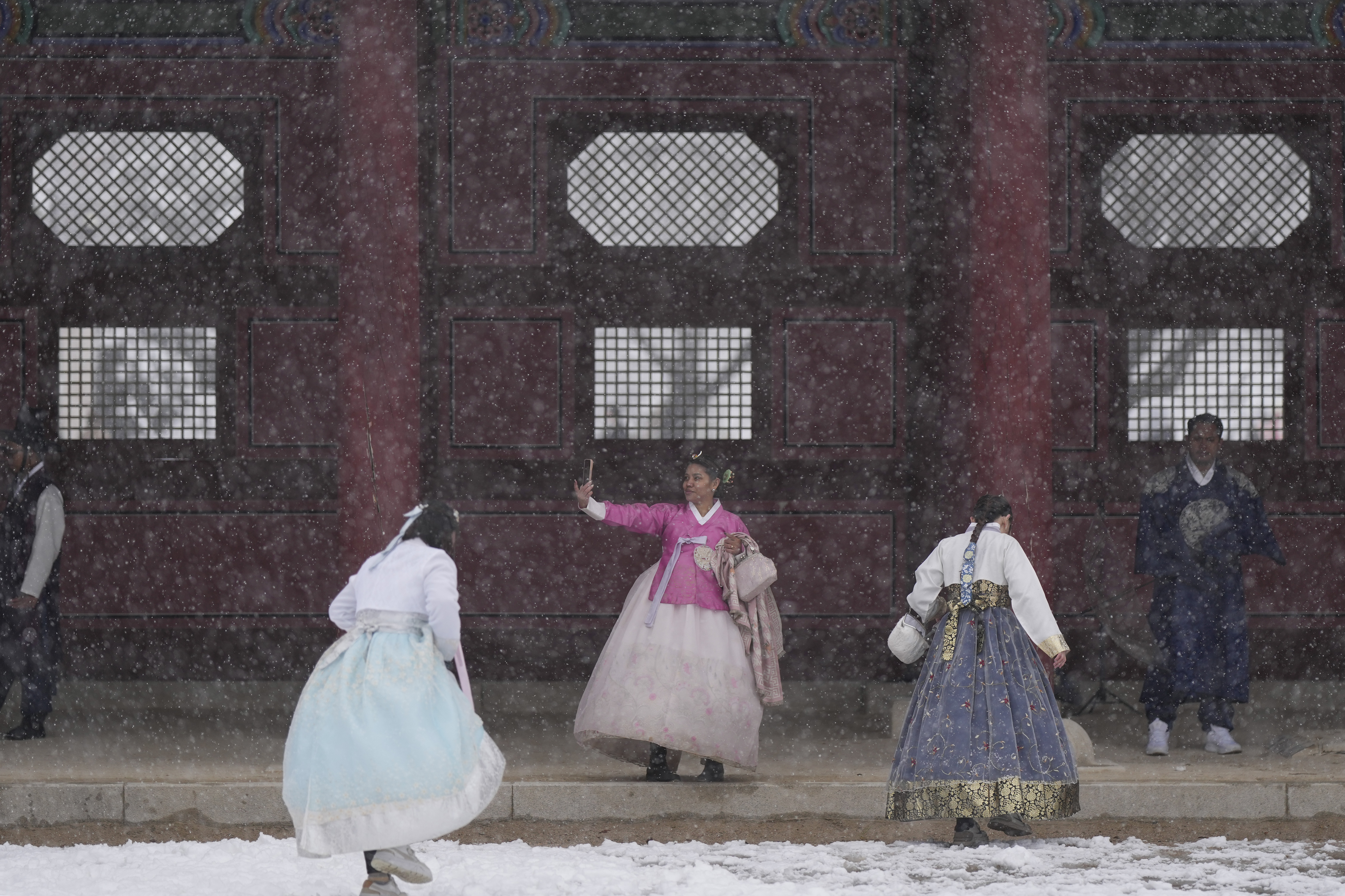 Visitors walk in snow at the Gyeongbok Palace, one of South Korea's well-known landmarks, in Seoul, South Korea, Wednesday, Nov. 27, 2024. (AP Photo/Lee Jin-man)