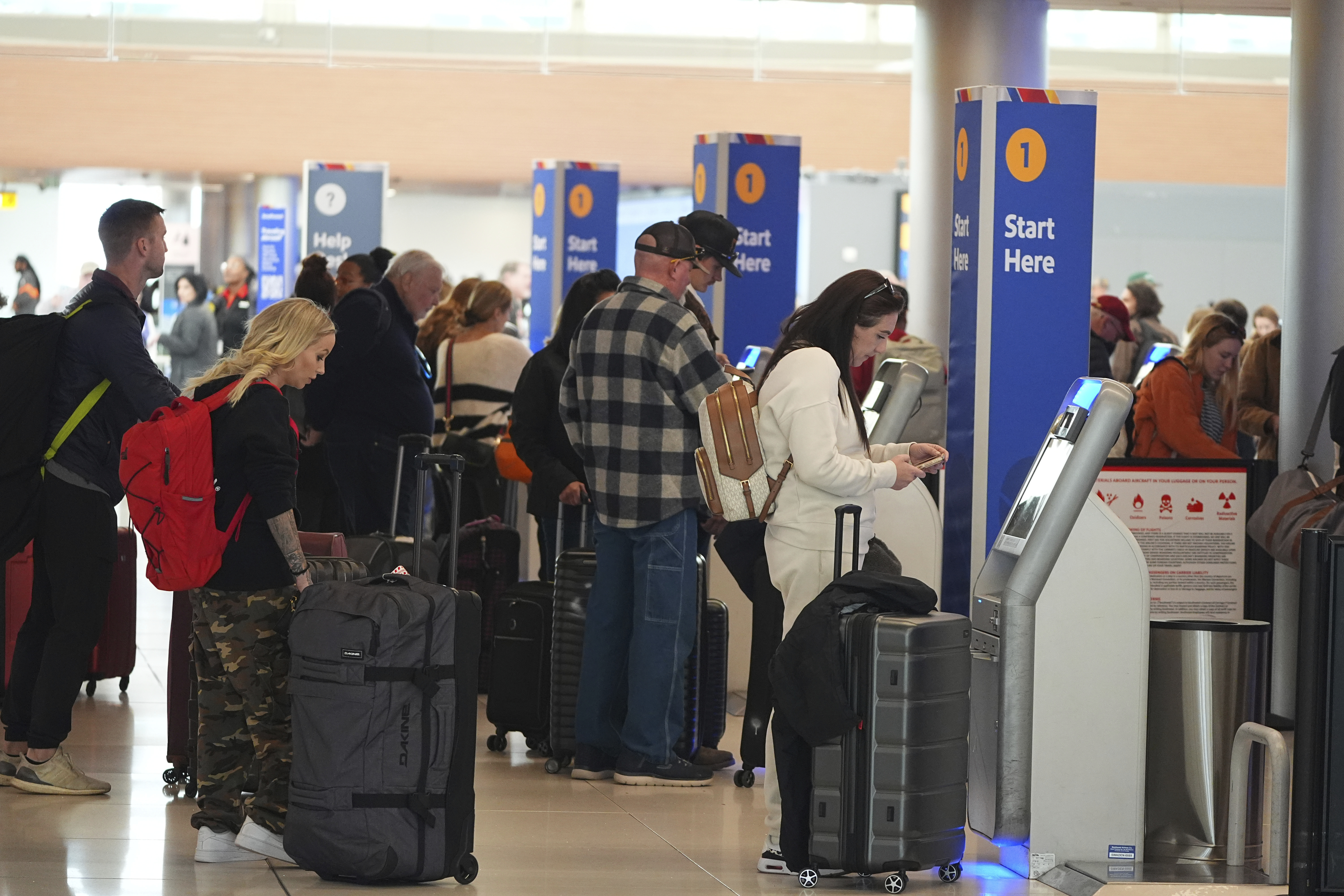 Travellers use kiosks to check in for flights on Southwest Airlines in Denver International Airport Tuesday, Nov. 26, 2024, in Denver. (AP Photo/David Zalubowski)