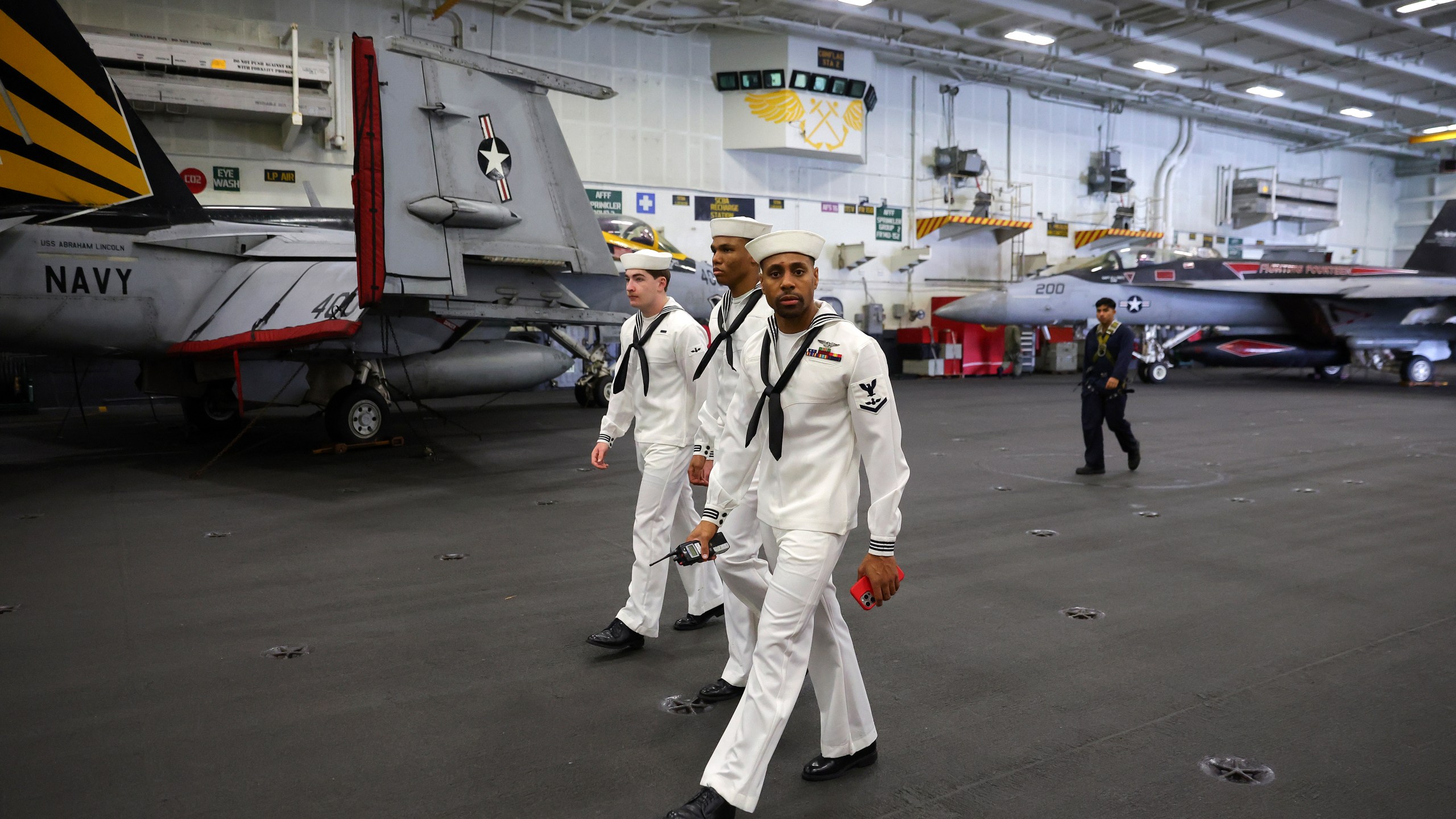 U.S. Navy officers walk inside the USS Abraham Lincoln during a media tour in Port Klang, on the outskirts of Kuala Lumpur, Malaysia, Tuesday, Nov. 26, 2024.(Fazry Ismail/Pool Photo via AP)