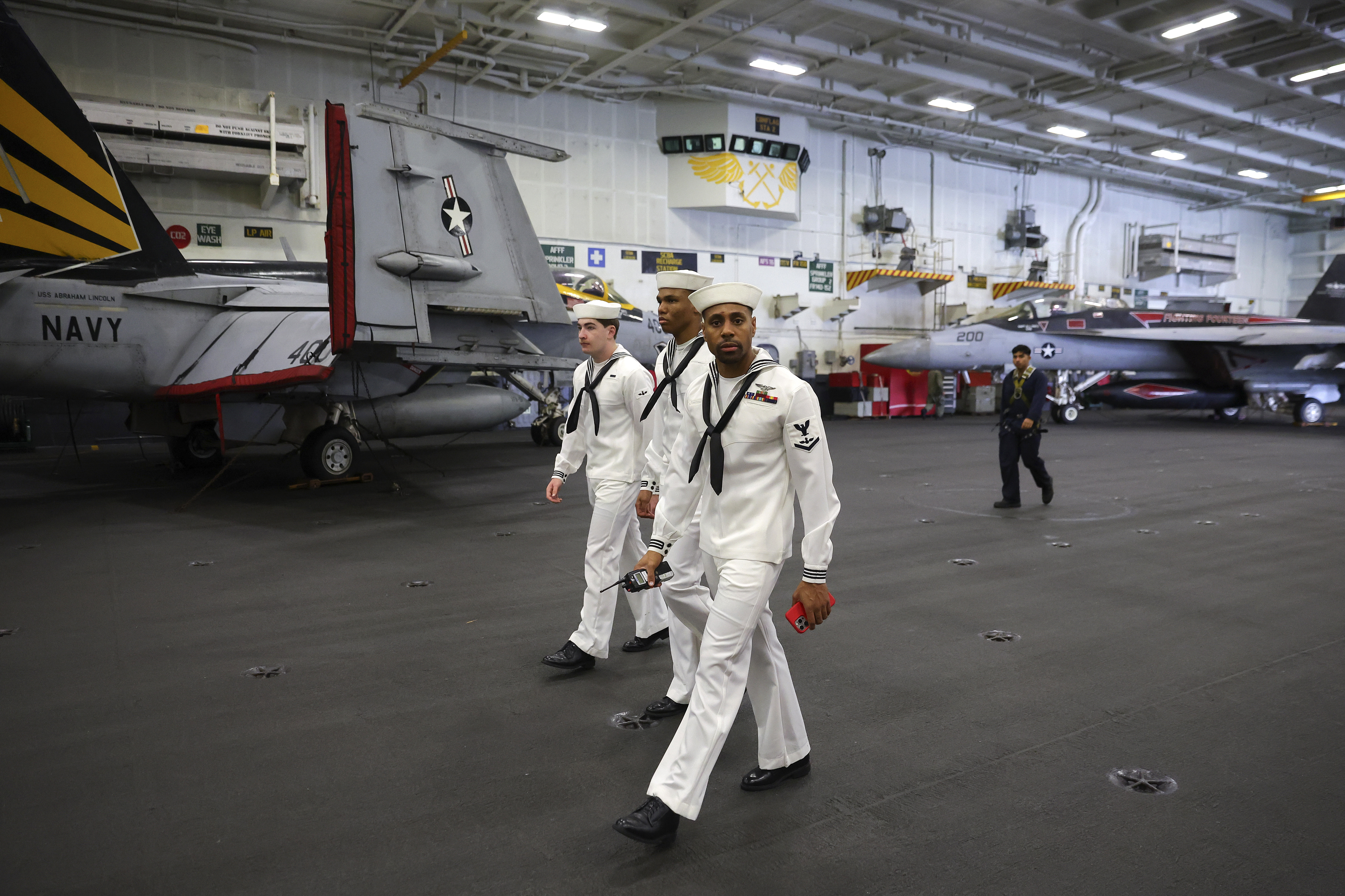 U.S. Navy officers walk inside the USS Abraham Lincoln during a media tour in Port Klang, on the outskirts of Kuala Lumpur, Malaysia, Tuesday, Nov. 26, 2024.(Fazry Ismail/Pool Photo via AP)