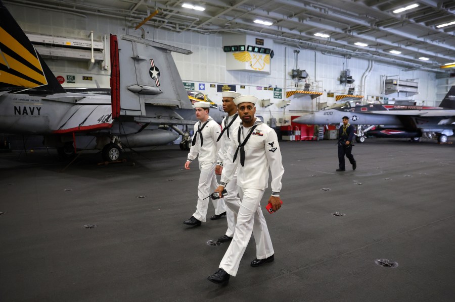 U.S. Navy officers walk inside the USS Abraham Lincoln during a media tour in Port Klang, on the outskirts of Kuala Lumpur, Malaysia, Tuesday, Nov. 26, 2024.(Fazry Ismail/Pool Photo via AP)