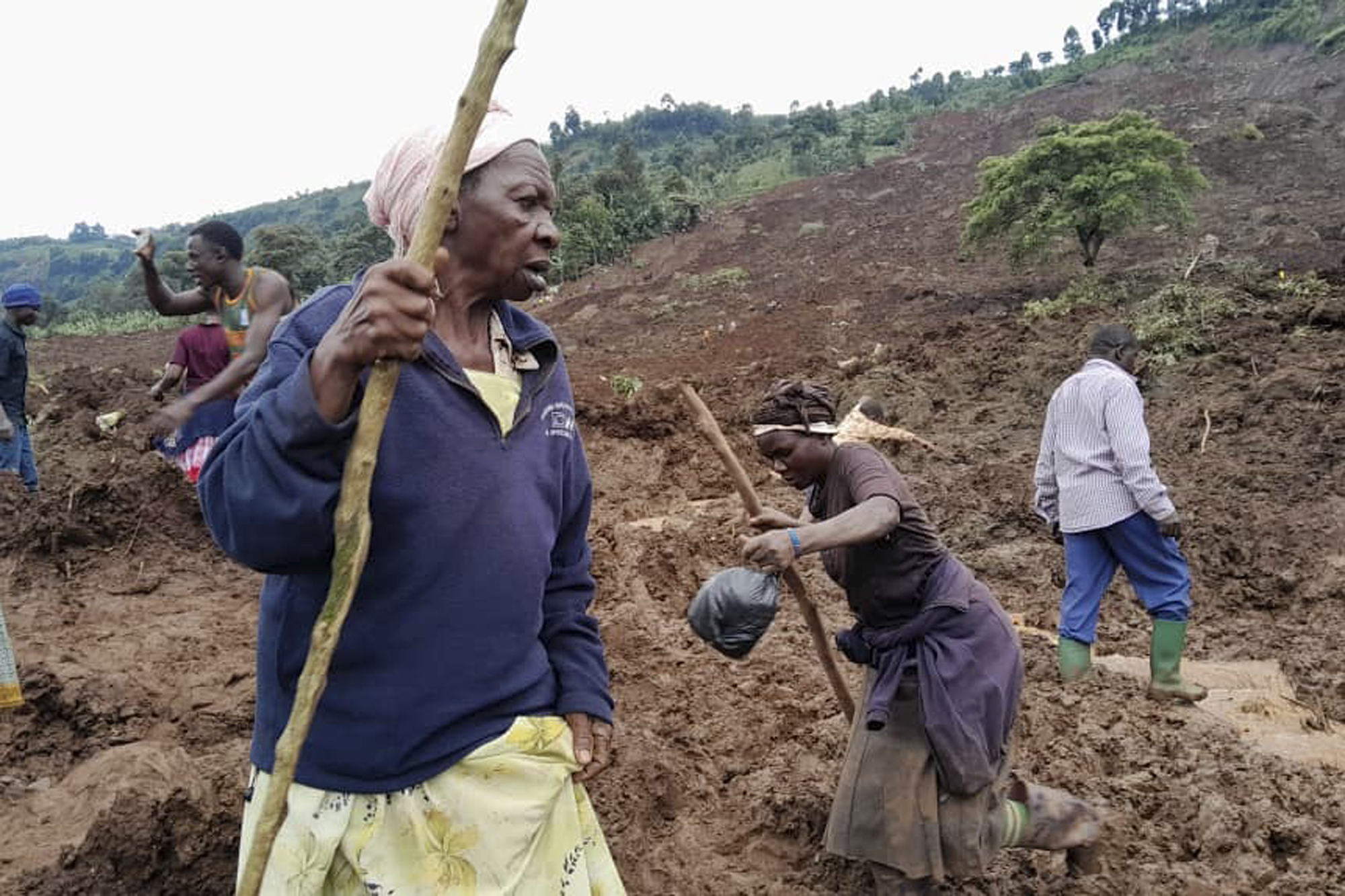 People search for bodies after landslides following heavy rains buried 40 homes in the mountainous district of Bulambuli, eastern Uganda, Thursday, Nov. 28. 2024. (AP Photo/Jean Watala)