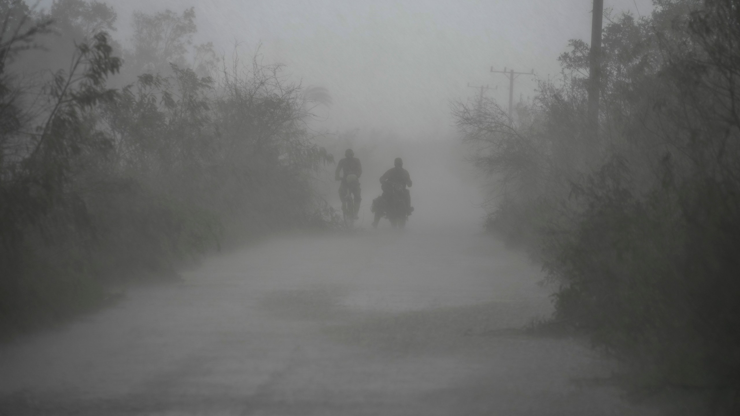 FILE - People travel in the rain after the passage of Hurricane Rafael in Guanimar, Cuba, Nov. 7, 2024. (AP Photo/Ramon Espinosa, File)