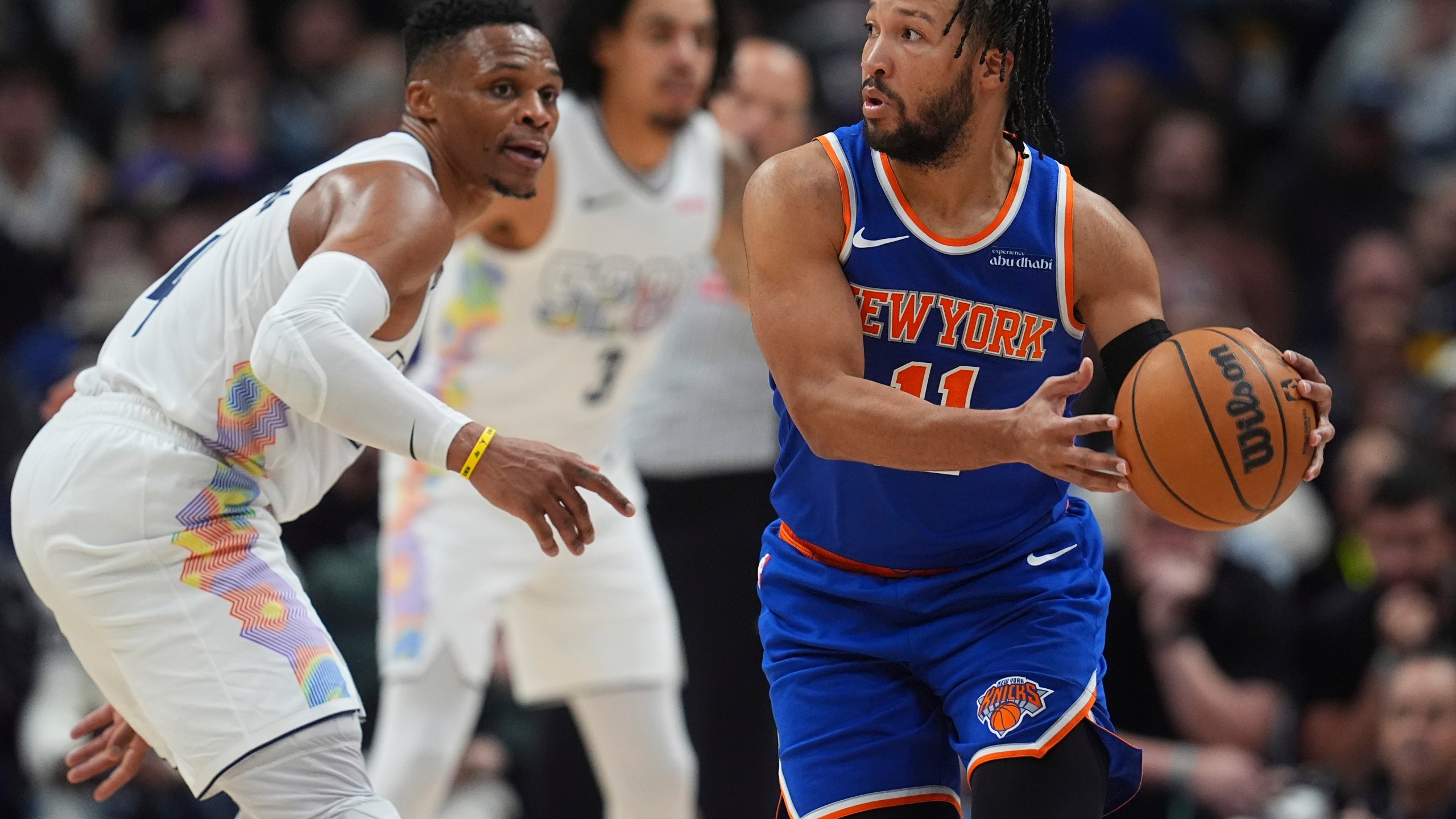 New York Knicks guard Jalen Brunson, right, looks to pass the ball as Denver Nuggets guard Russell Westbrook defends in the second half of an NBA basketball game Monday, Nov. 25, 2024, in Denver. (AP Photo/David Zalubowski)