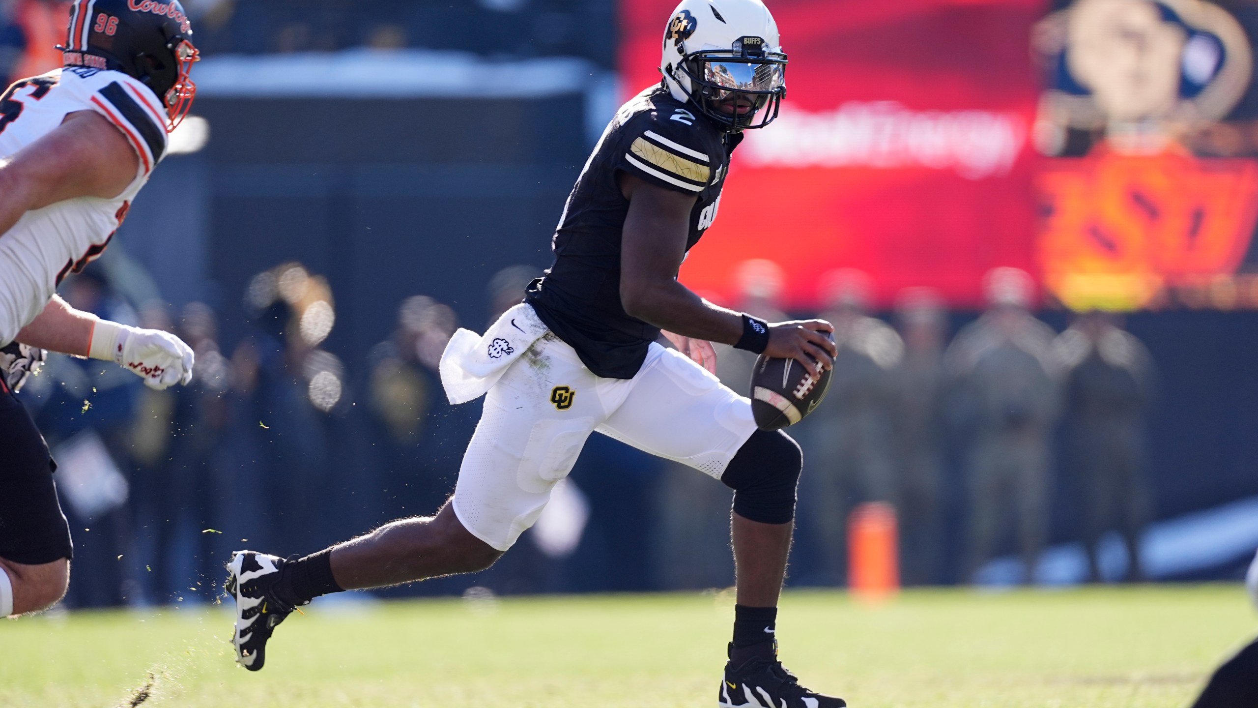 Colorado quarterback Shedeur Sanders avoids Oklahoma State safety Talon Kendrick in the first half of an NCAA college football game Friday, Nov. 29, 2024, in Boulder, Colo. (AP Photo/David Zalubowski)