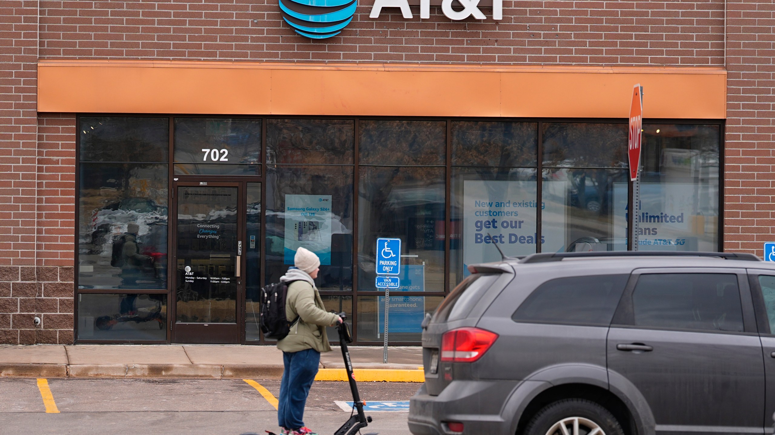 FILE - The company logo hangs over the door to a AT&T telephone store, Feb. 22, 2024, in Denver. (AP Photo/David Zalubowski, file)