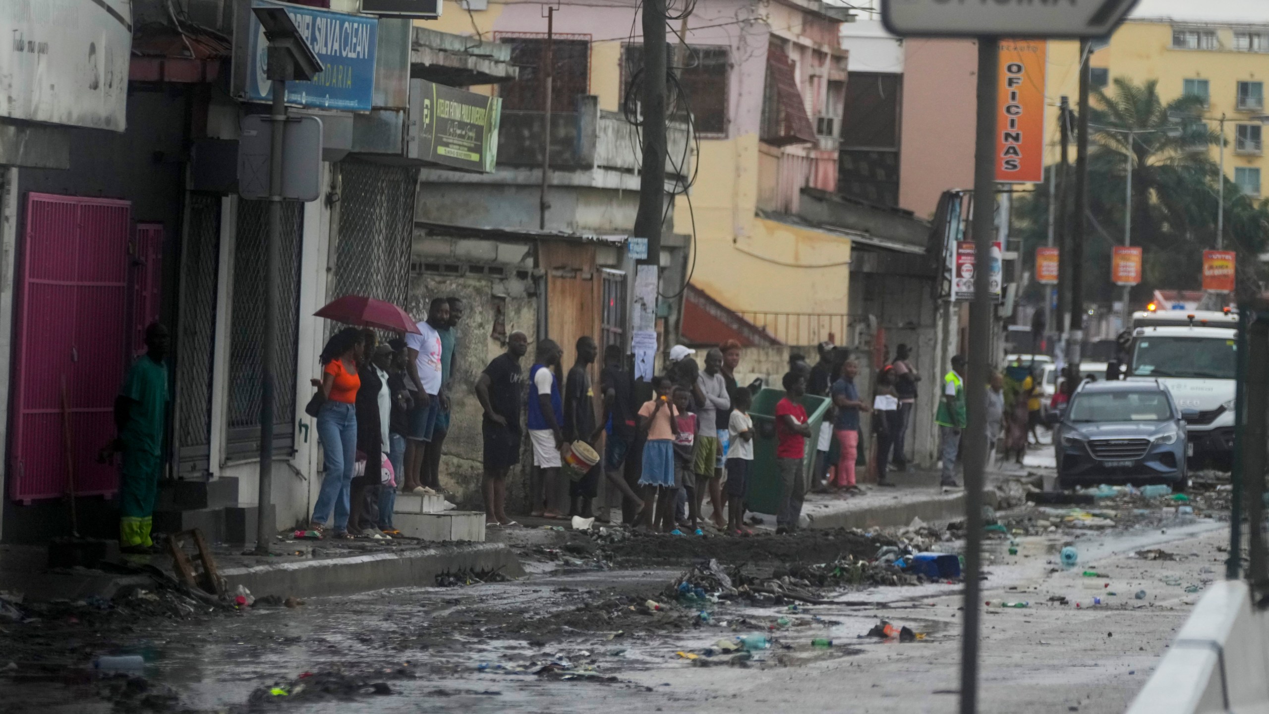 People watch President Joe Biden's motorcade drive through Luanda, Angola, Tuesday, Dec. 3, 2024. (AP Photo/Ben Curtis)