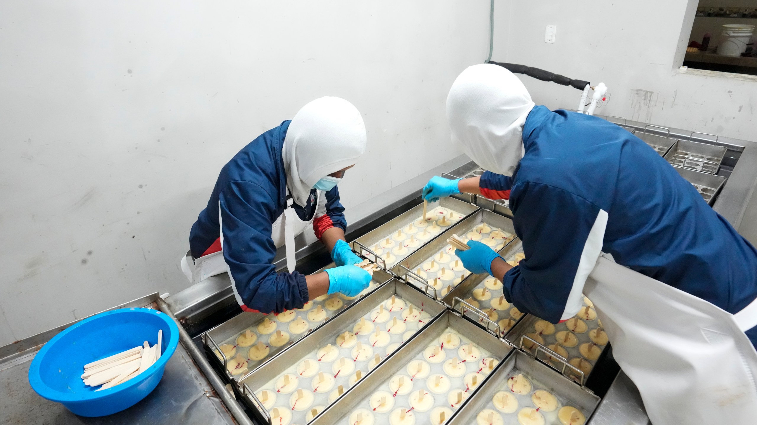 Workers prepare popsicles at an artisanal factory in Salcedo, Ecuador, Thursday, Nov. 28, 2024, amid a wave of power outages, triggered by a prolonged dry spell. (AP Photo/Dolores Ochoa)