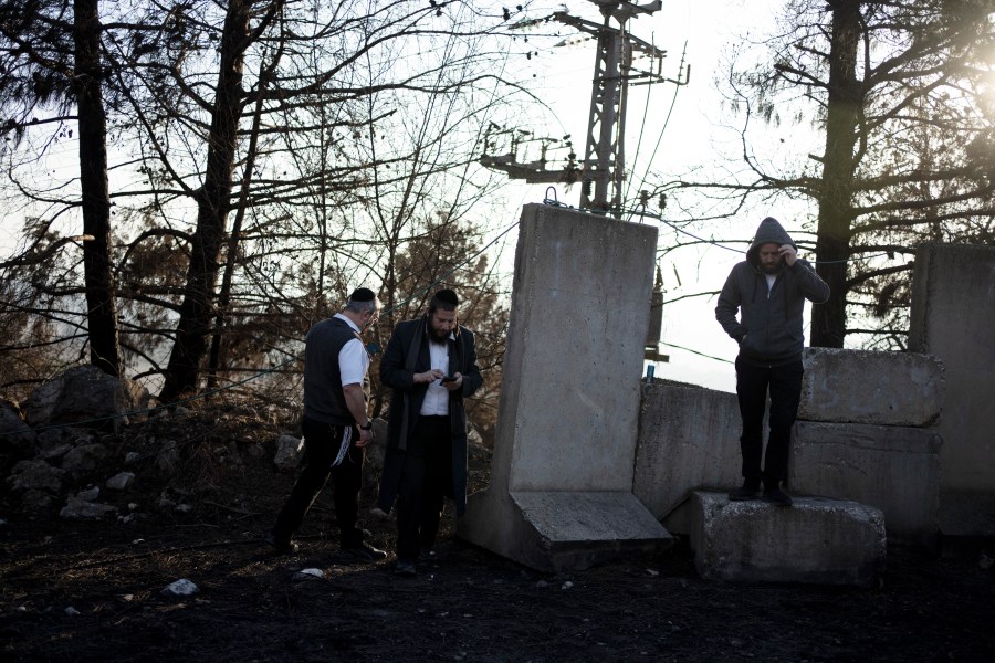 Ultra-Orthodox Jewish men tour northern Israel, near the border with Lebanon, during a ceasefire, Tuesday, Dec. 3, 2024. (AP Photo/Maya Alleruzzo)