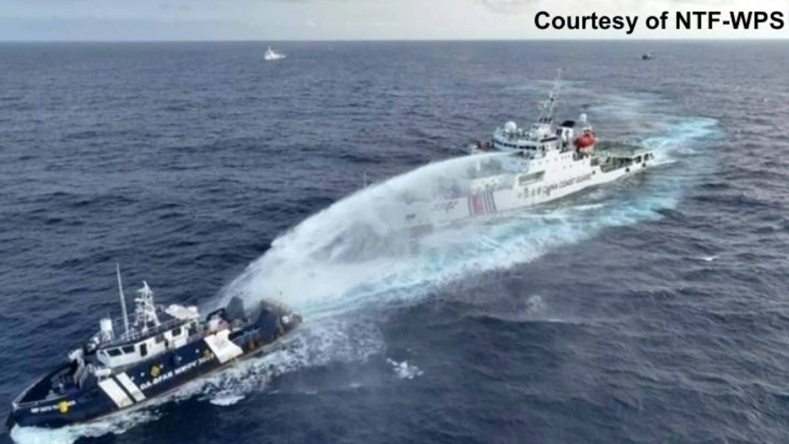 In this image taken from a video provided by National Task Force for the West Philippine Sea (NTF-WPS), a Chinese coast guard vessel, right, fires a powerful water cannon on a Philippine bureau of fisheries vessel near a disputed shoal in the South China Sea Wednesday, Dec. 4, 2024. (NTF-WPS via AP)