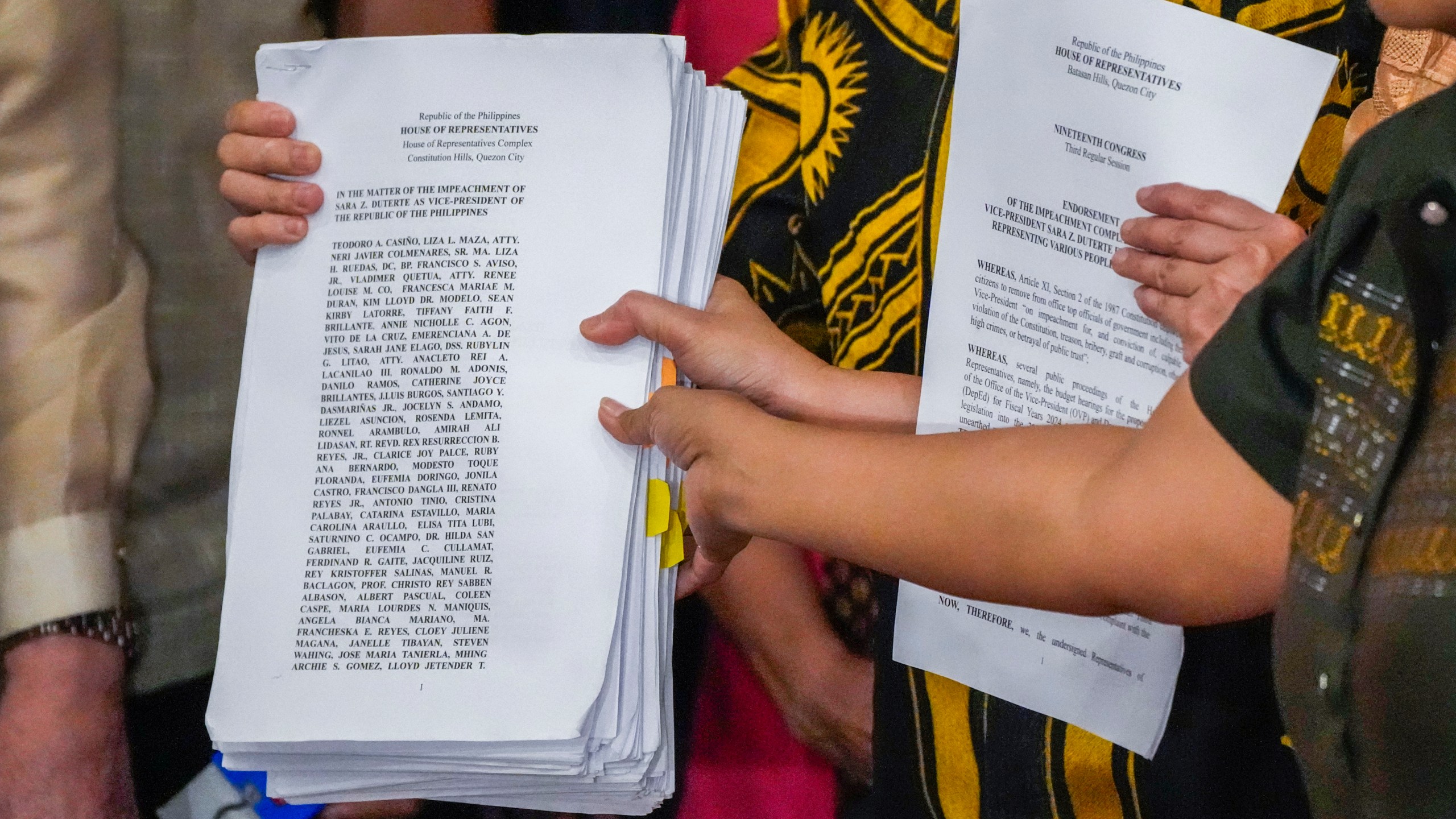 Activists hold a copy of a second impeachment complaint filed against Philippine Vice President Sara Duterte on Wednesday Dec. 4, 2024 at the House of Representatives in Quezon City, Philippines. (AP Photo/Aaron Favila)