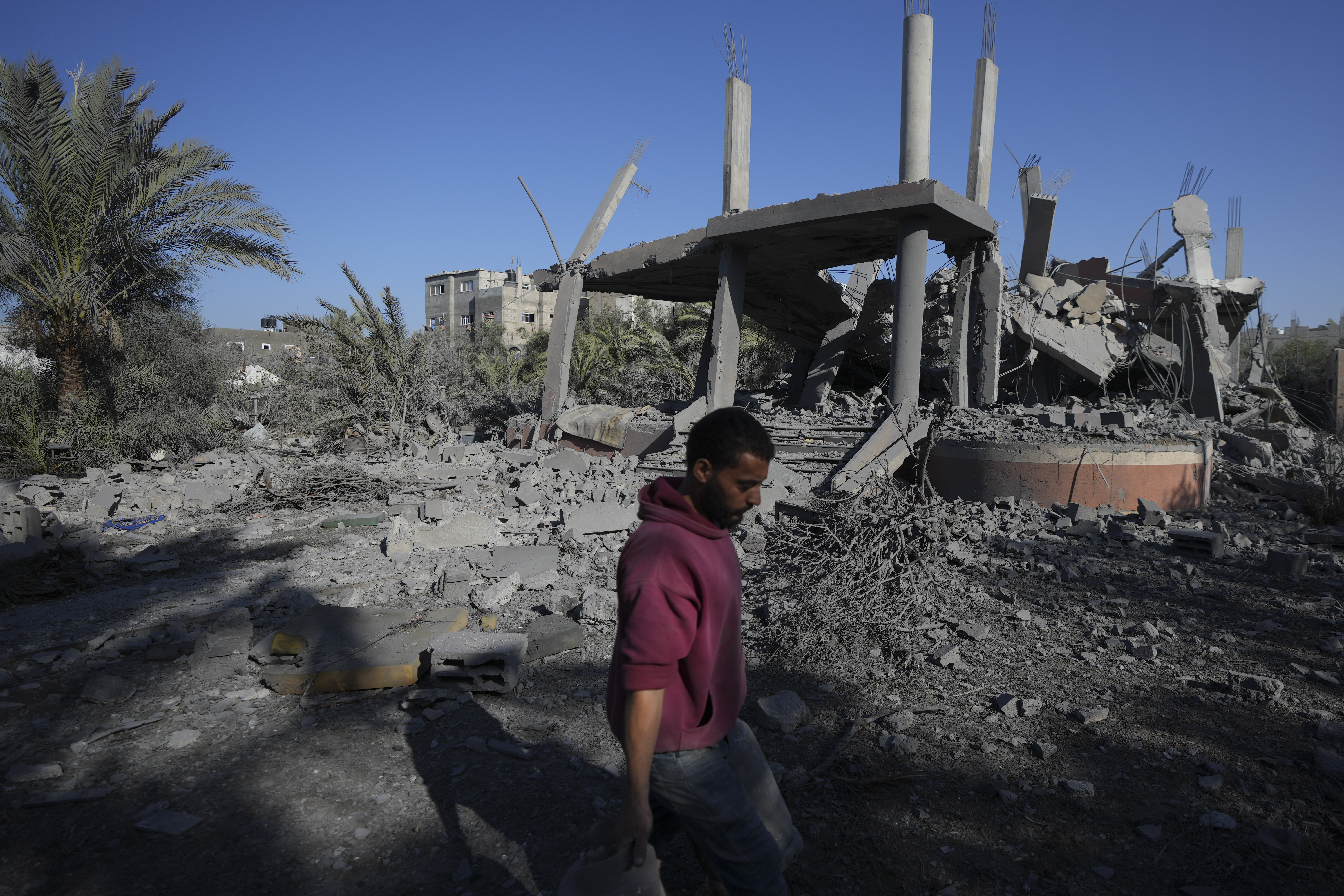 A Palestinian walks past a destroyed building following an overnight Israeli strike in Deir al-Balah, Gaza Strip, Wednesday, Dec. 4, 2024. (AP Photo/Abdel Kareem Hana)