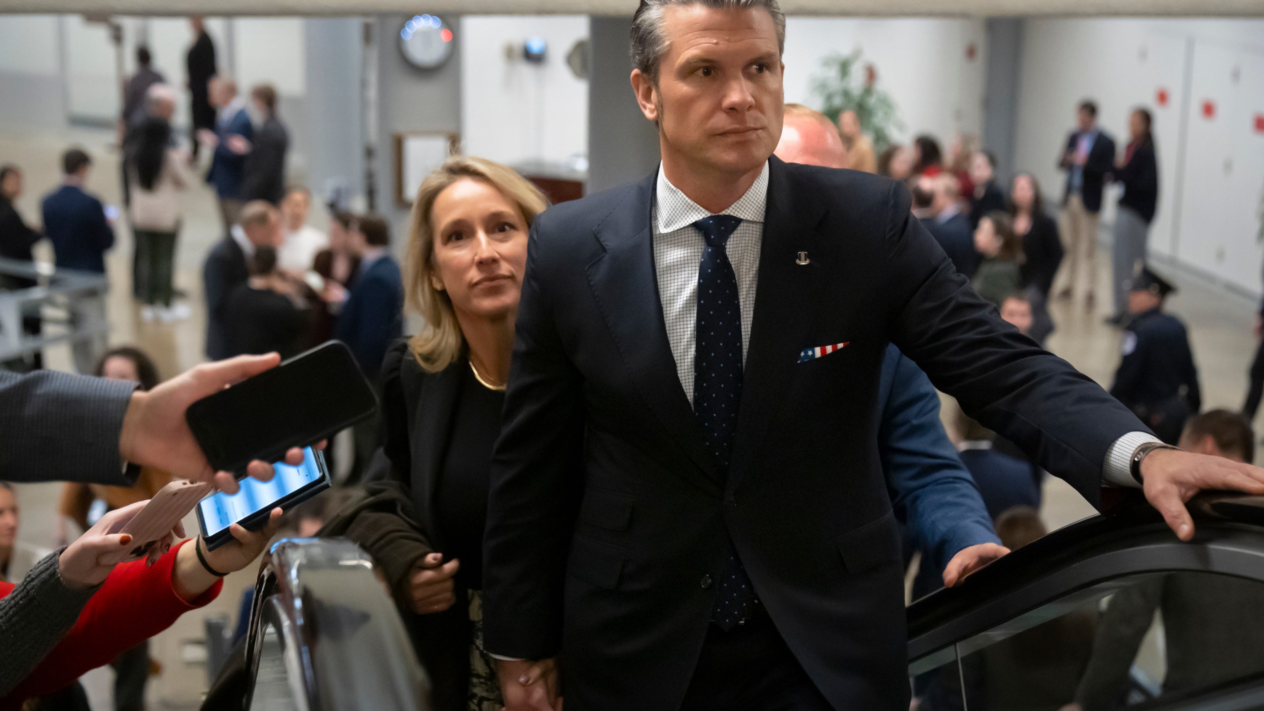 Pete Hegseth, President-elect Donald Trump's nominee to be defense secretary, is joined by his wife Jennifer Rauchet, as they walk through the basement of the Capitol, Wednesday, Dec. 4, 2024, in Washington. (AP Photo/Mark Schiefelbein)