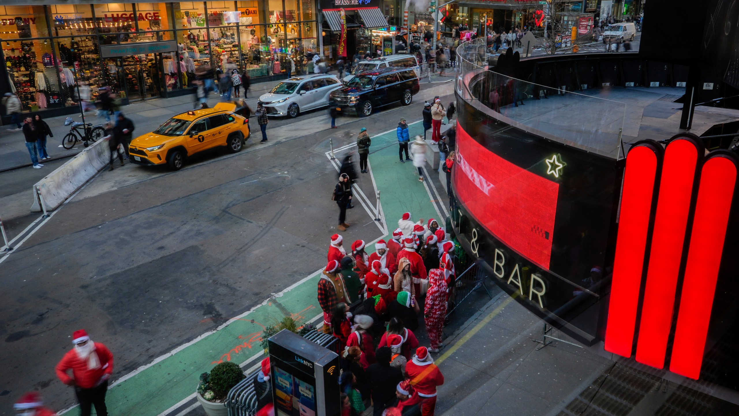 Revellers line up to enter a bar during SantaCon, Saturday, Dec. 14, 2024, in New York. (AP Photo/Julia Demaree Nikhinson)