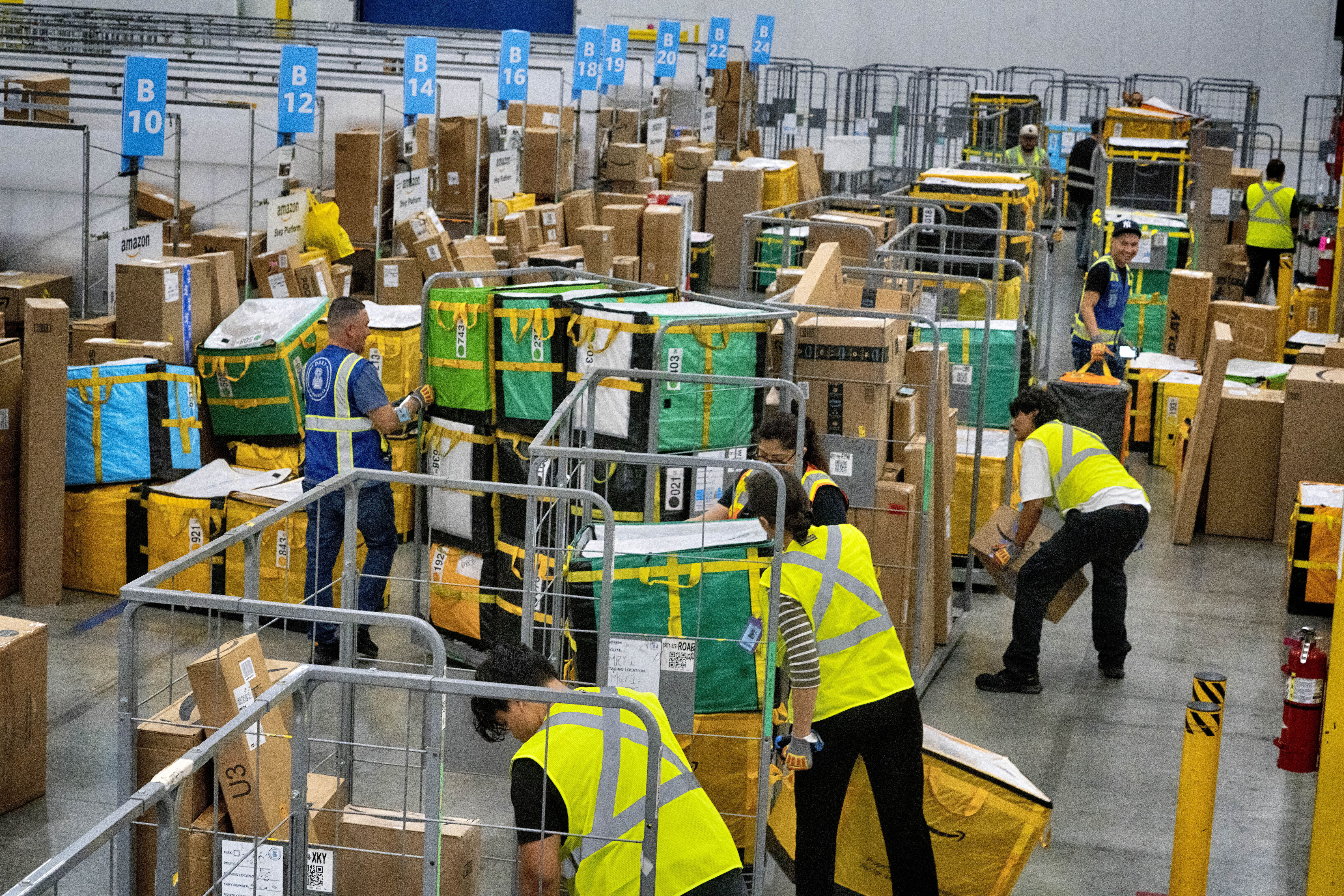 FILE - Amazon employees load packages on carts before being put on to trucks for distribution for Amazon's annual Prime Day event at an Amazon's DAX7 delivery station on July 16, 2024, in South Gate, Calif. (AP Photo/Richard Vogel, File)