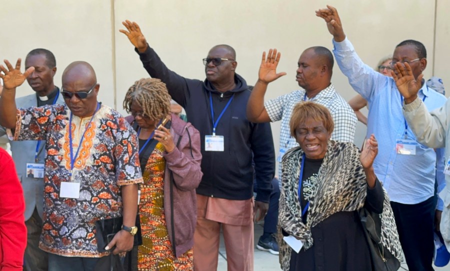 FILE - African delegates to the General Conference of the United Methodist Church pray outside the Charlotte Convention Center, in Charlotte, N.C., Thursday, May 2, 2024. (AP Photo/Peter Smith, File)