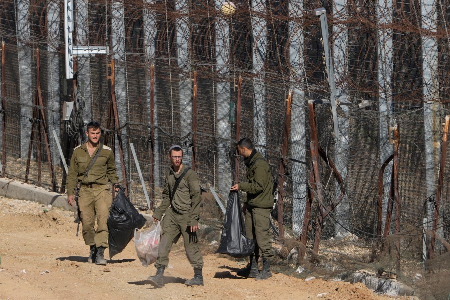 Israeli soldiers clean along the so-called Alpha Line that separates the Israeli-controlled Golan Heights from Syria, in the town of Majdal Shams, Tuesday, Dec. 17, 2024. (AP Photo/Matias Delacroix)